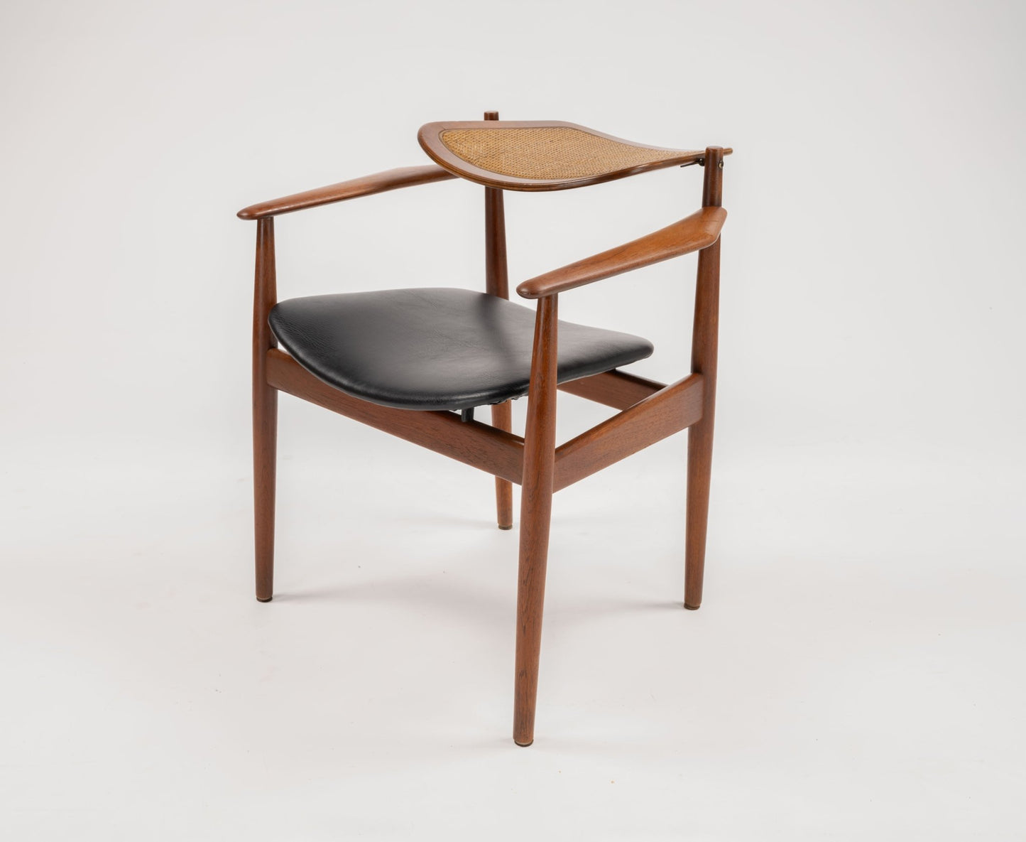 Mid-century modern Arne Vodder dining chair with teak frame, hinged cane backrest, and black leather seat cushion