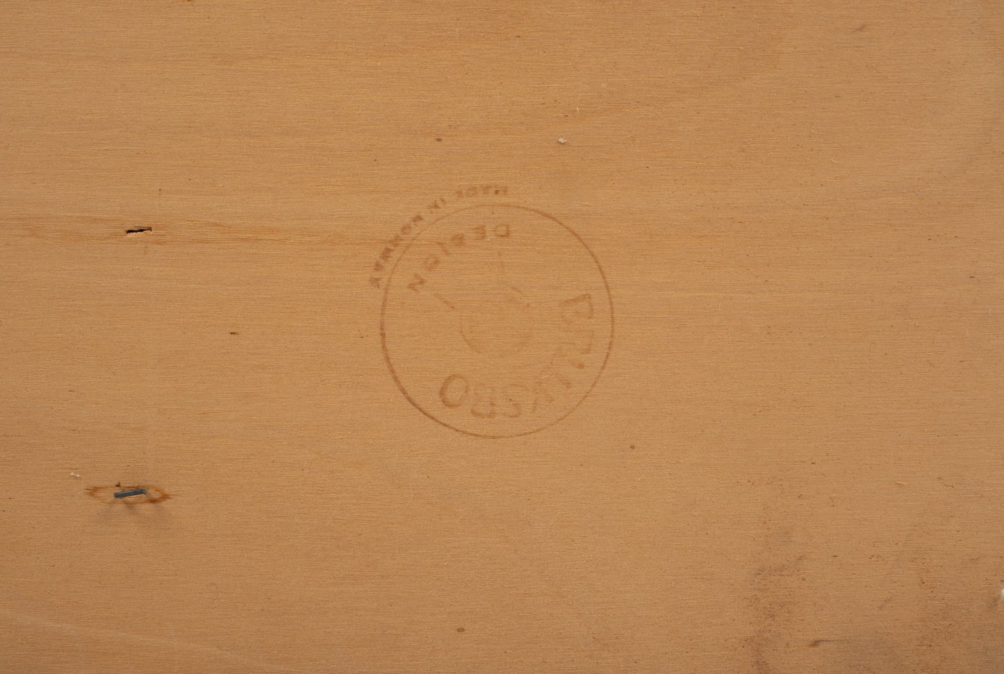 Close-up of Bruksbo brand stamp on light wood surface of rosewood rolling cart showing maker's mark details.