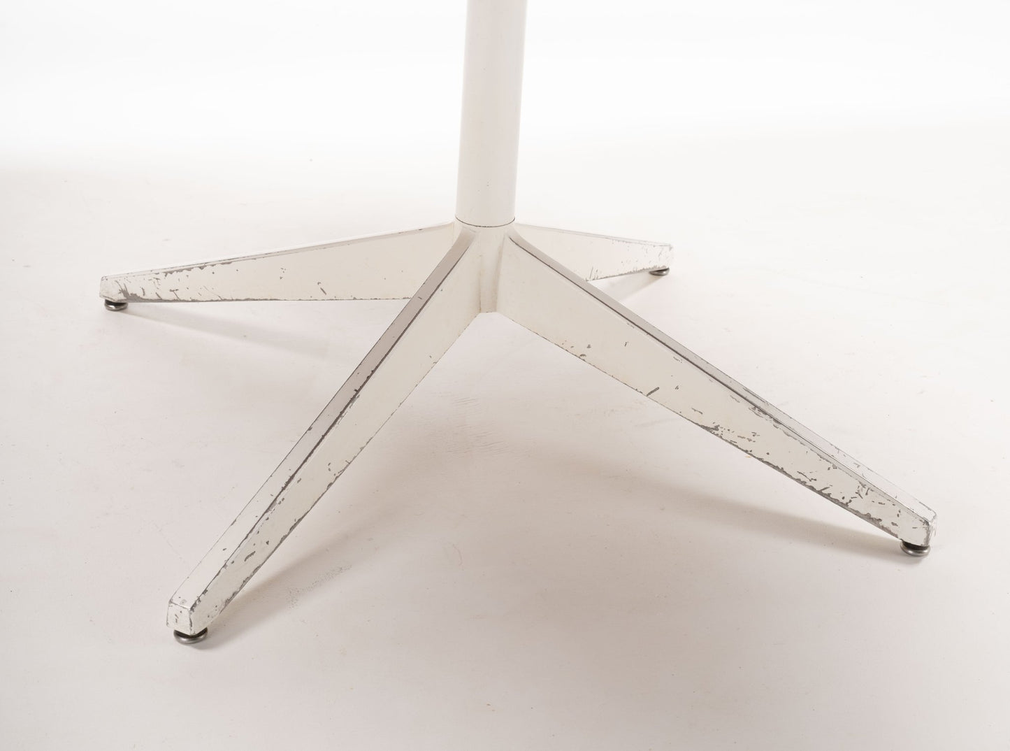White powder-coated metal star-shaped base of mid-century modern George Nelson Lazy Susan table.