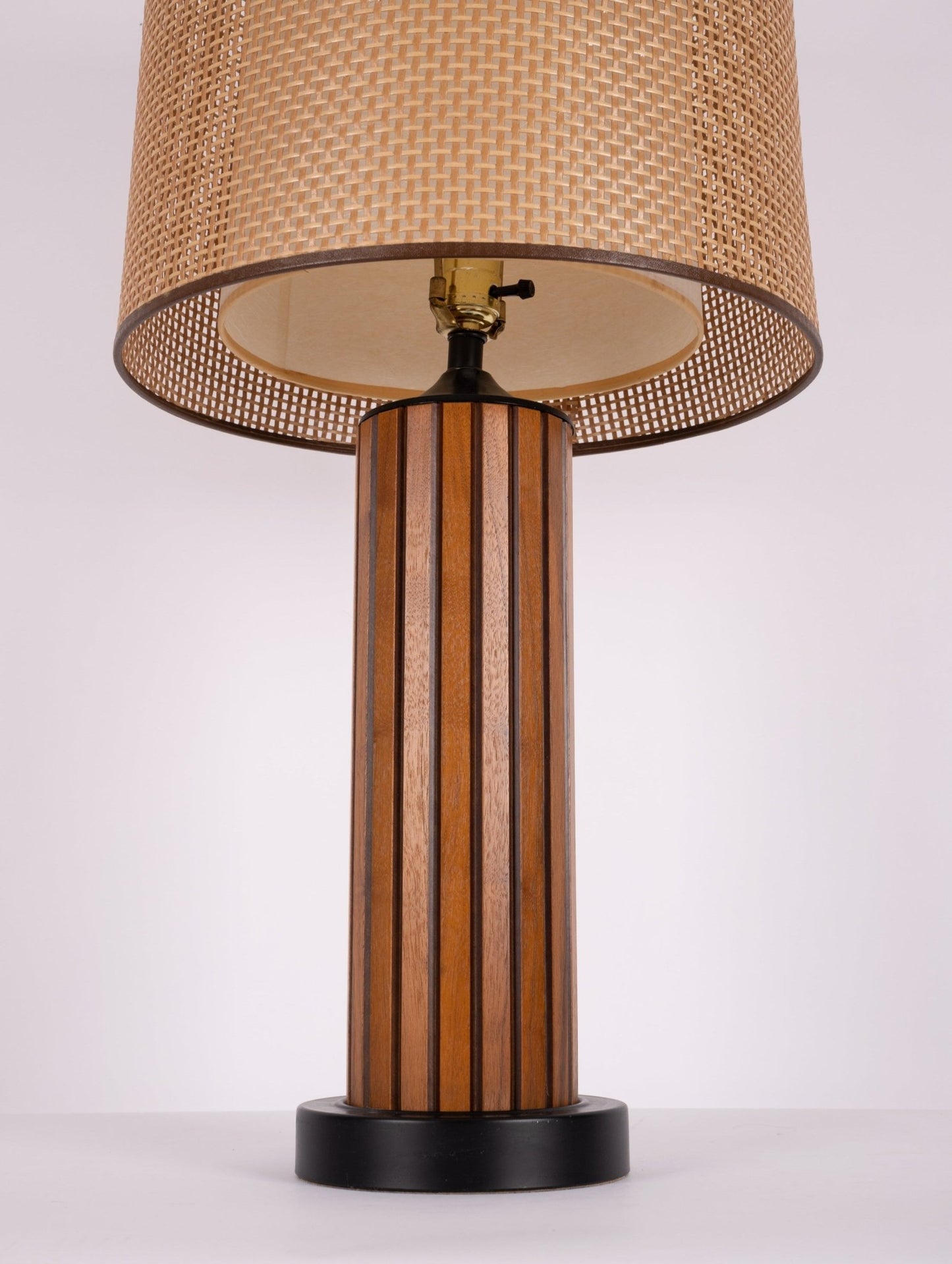 1960s vintage walnut table lamp with fluted wood body, black base, and cane shade with diffuser detail