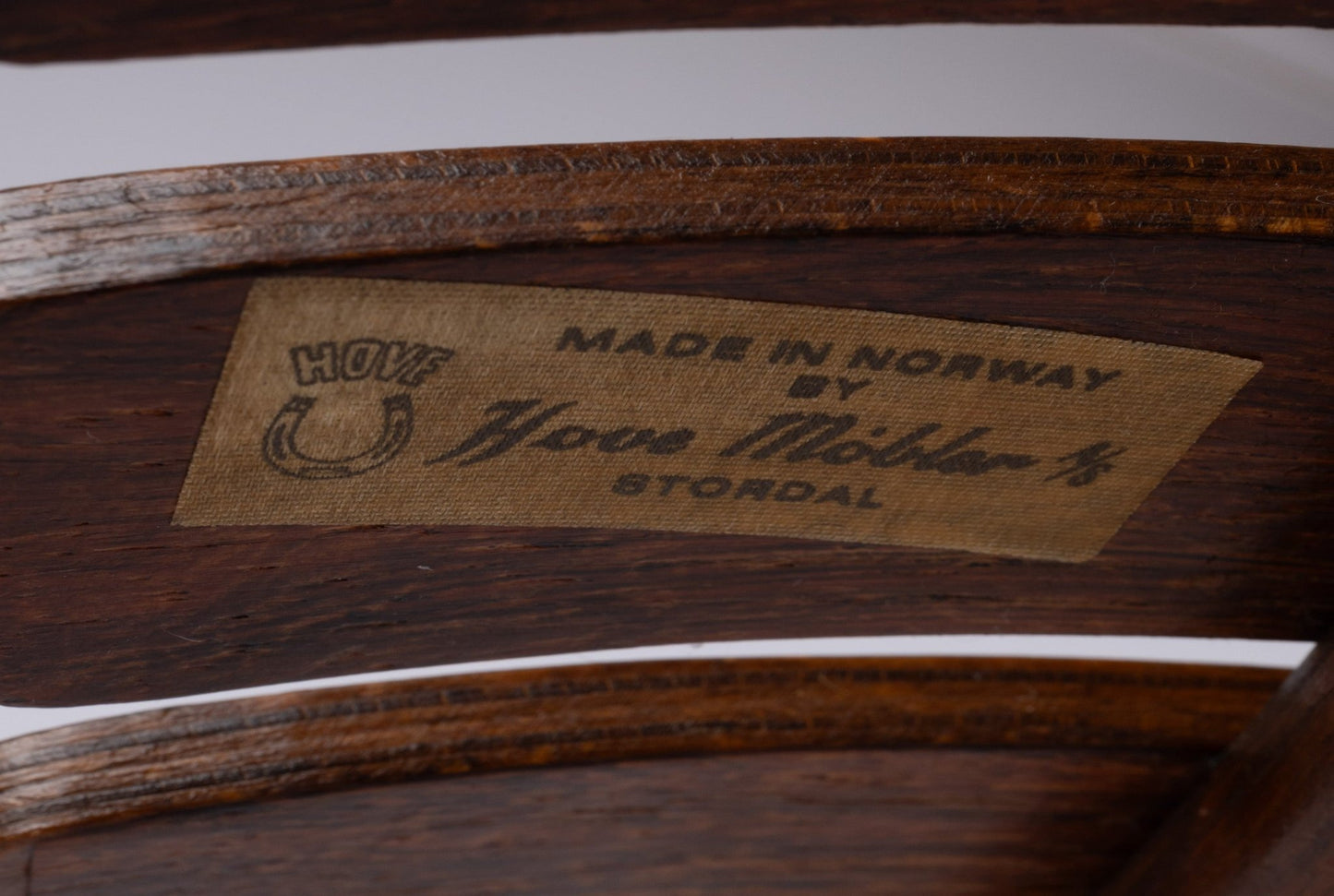 Close-up of Hove Mobler label inside curved laminated rosewood slats on 1960s Norwegian Hans Brattrud dining chair