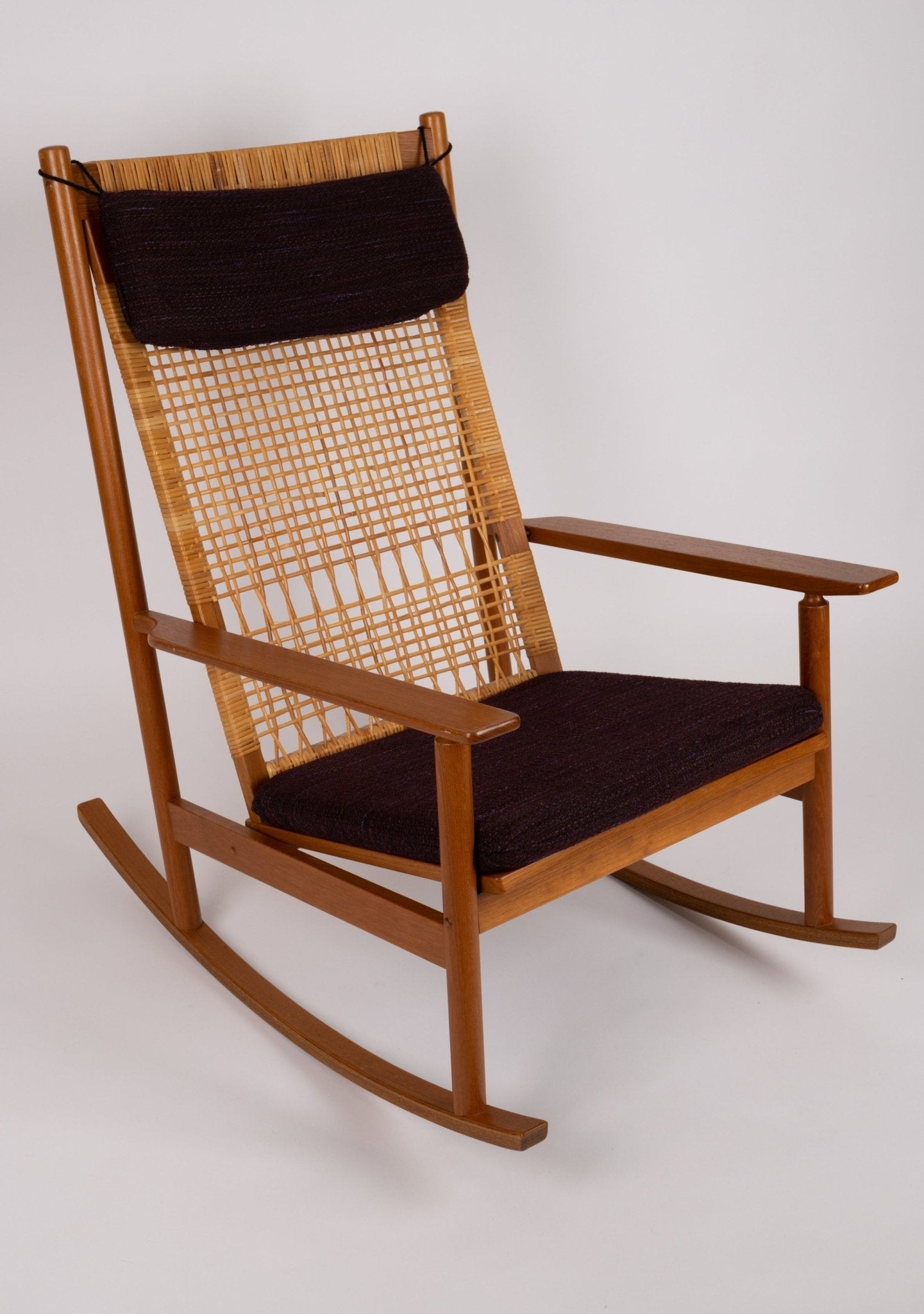 Hans Olsen 1960s Danish teak rocking chair with woven cane back and black upholstered cushions by Juul Kristensen