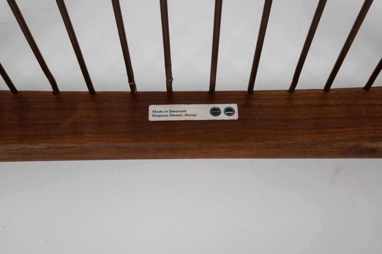 Close-up of teak frame with Magnus Olesen maker's label on Kai Kristiansen 'Paper Knife' chair from 1950s Denmark