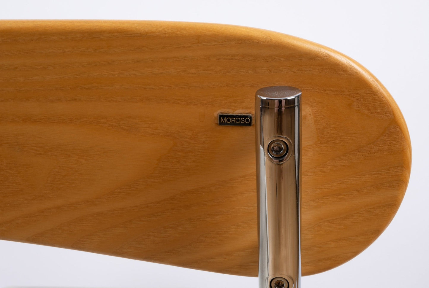 Close-up of wooden backrest with chrome support and Moroso maker's mark on Massimo Iosa Ghini Memphis style arm chair
