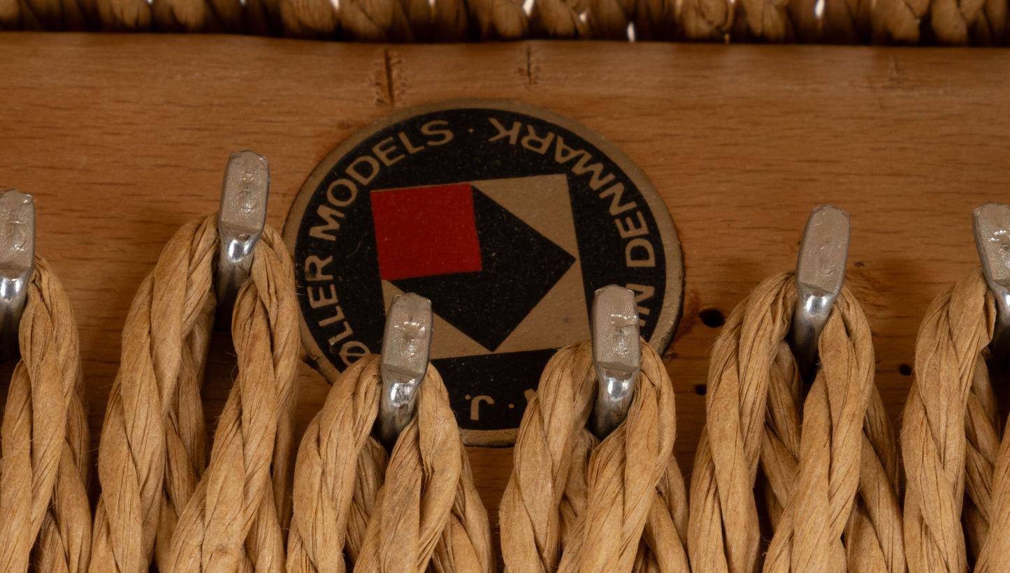 Close-up of woven papercord seat detail and J.L. Mollers Mobelfabrik maker's mark on Niels Otto Moller teak dining chair