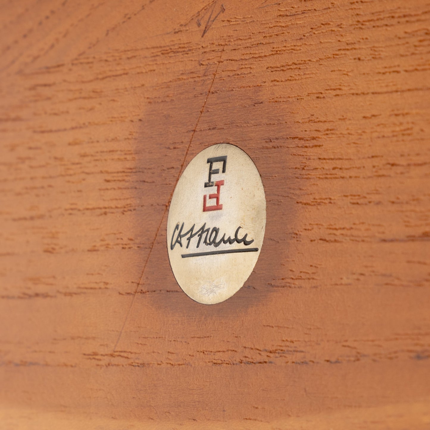 Peter Hvidt Teak Coffee Table Model FD-515 displaying a close-up of the authentic maker's label set into smooth teak wood, highlighting vintage Danish mid century modern craftsmanship.