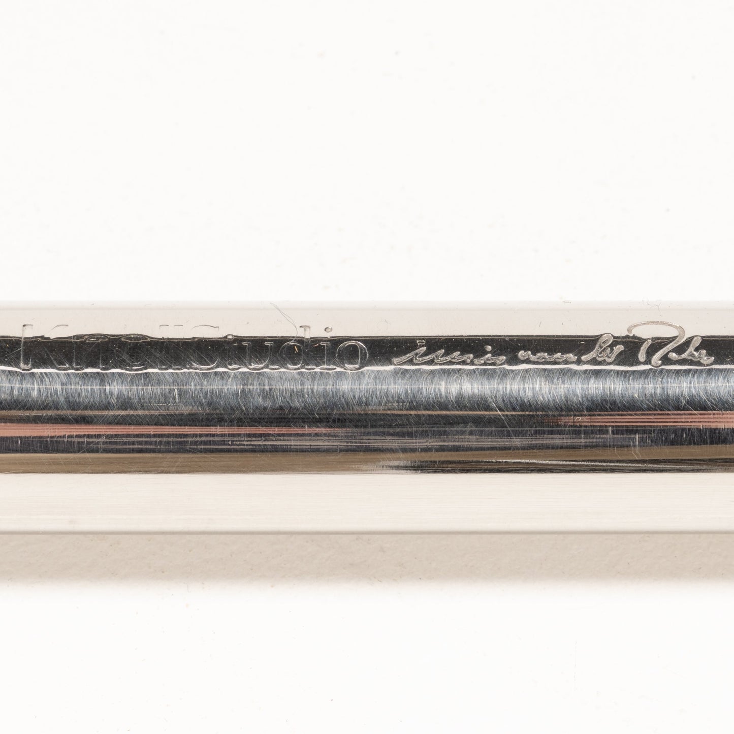 Close-up of engraved signature and branding detail on polished chrome tubular frame of Van Der Rohe MR10 chair