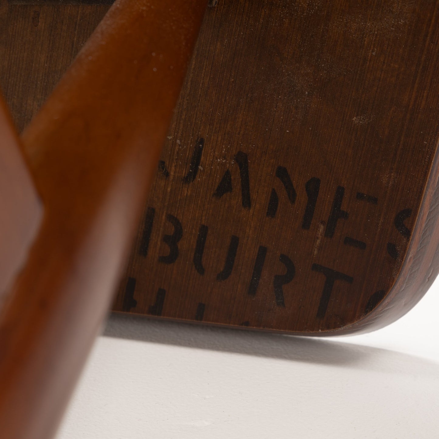 Walnut Side Table with Laminate Top featuring a close-up detail of its rich walnut wood base with smooth finish and subtle stamped markings, highlighting craftsmanship in mid century modern furniture.