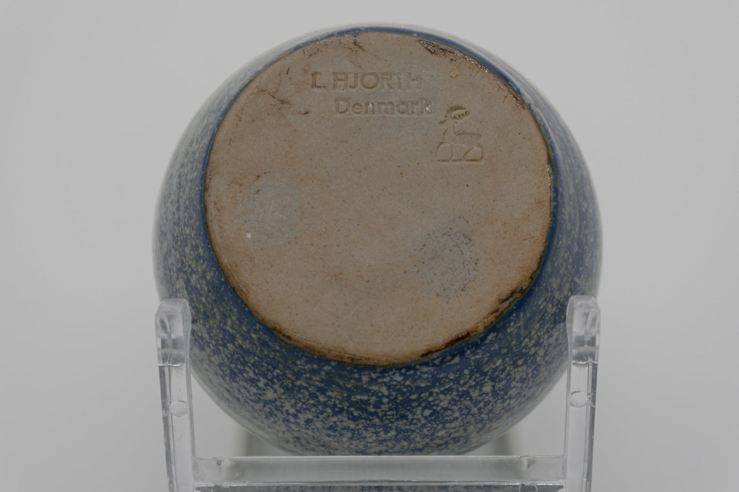 Bottom view of L. Hjorth stoneware vase with blue spotted glaze and Danish maker's mark on clear stand