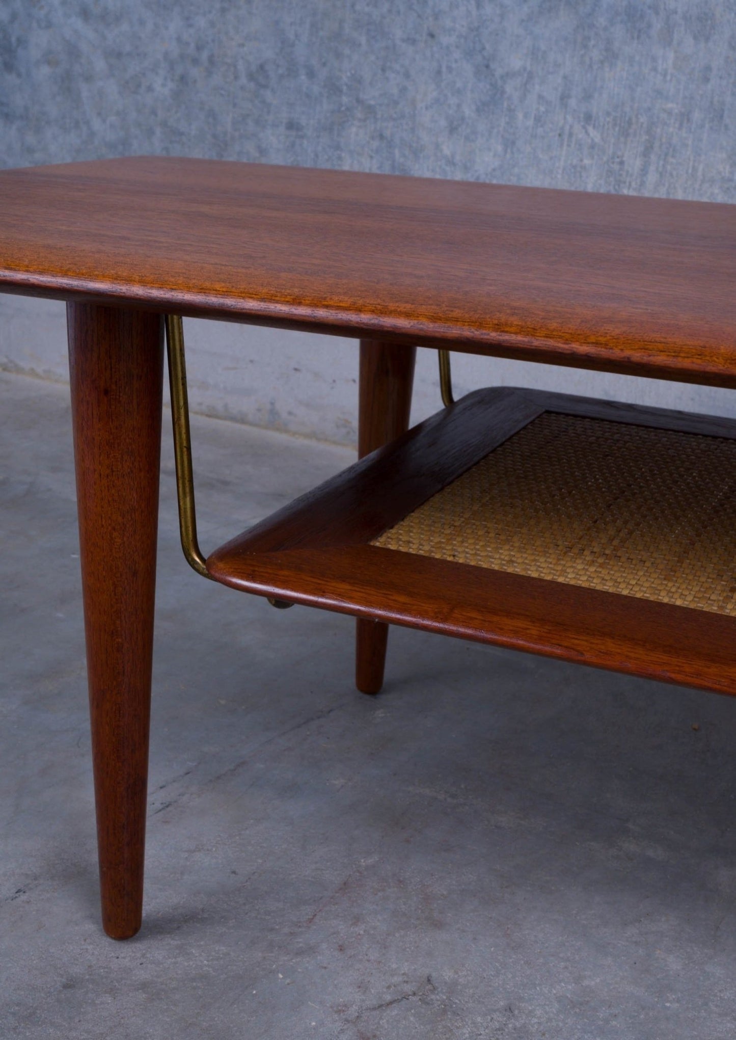 Mid-century modern teak coffee table with tapered legs and lower cane shelf, designed by Hvidt and Mølgaard-Nielsen.