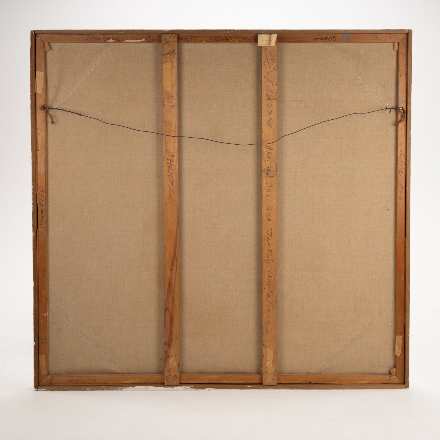 48-Inch Framed Painting by A. Harris '68 showing the reverse side with stretched canvas, wooden frame, reinforced crossbars, and a hanging wire for wall mounting.