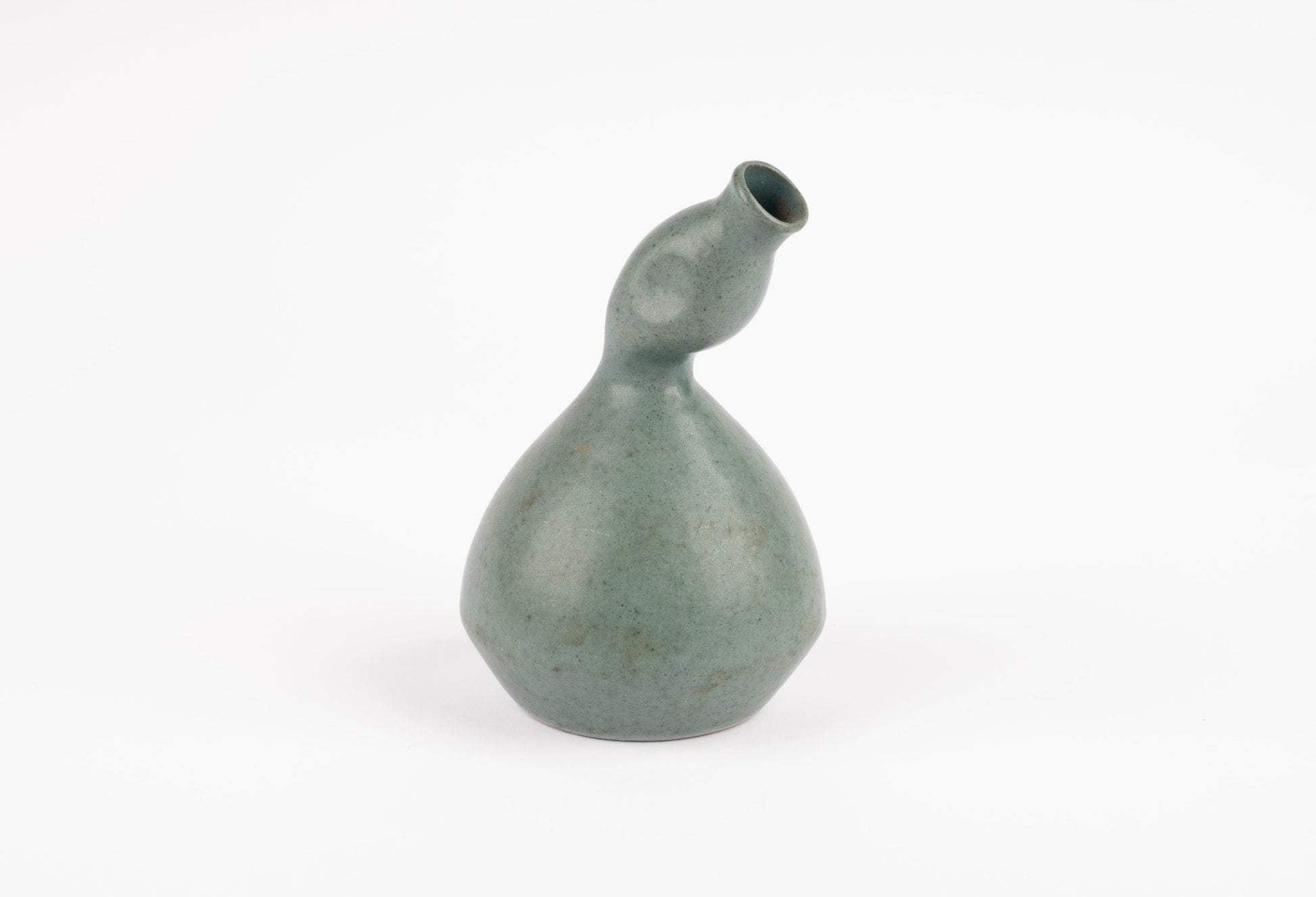 Abstract celadon studio pottery vase with gently swelling body and tilted neck, hand-formed with subtle green glaze