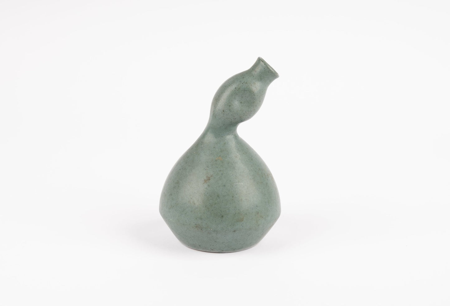 Abstract celadon studio pottery vase with gently swelling body and tilted neck, hand-formed with soft green glaze