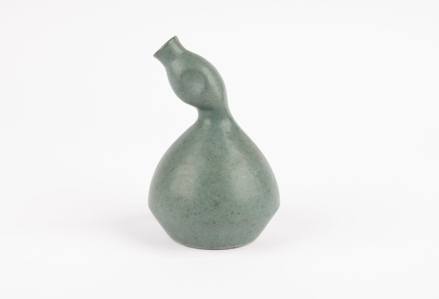 Abstract celadon studio pottery vase with gently swelling body and tilted neck, hand-formed with subtle glaze
