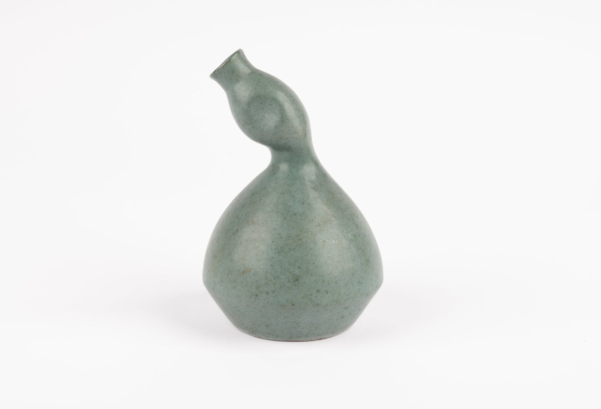 Abstract celadon studio pottery vase with gently swelling body and tilted neck, hand-formed with subtle glaze