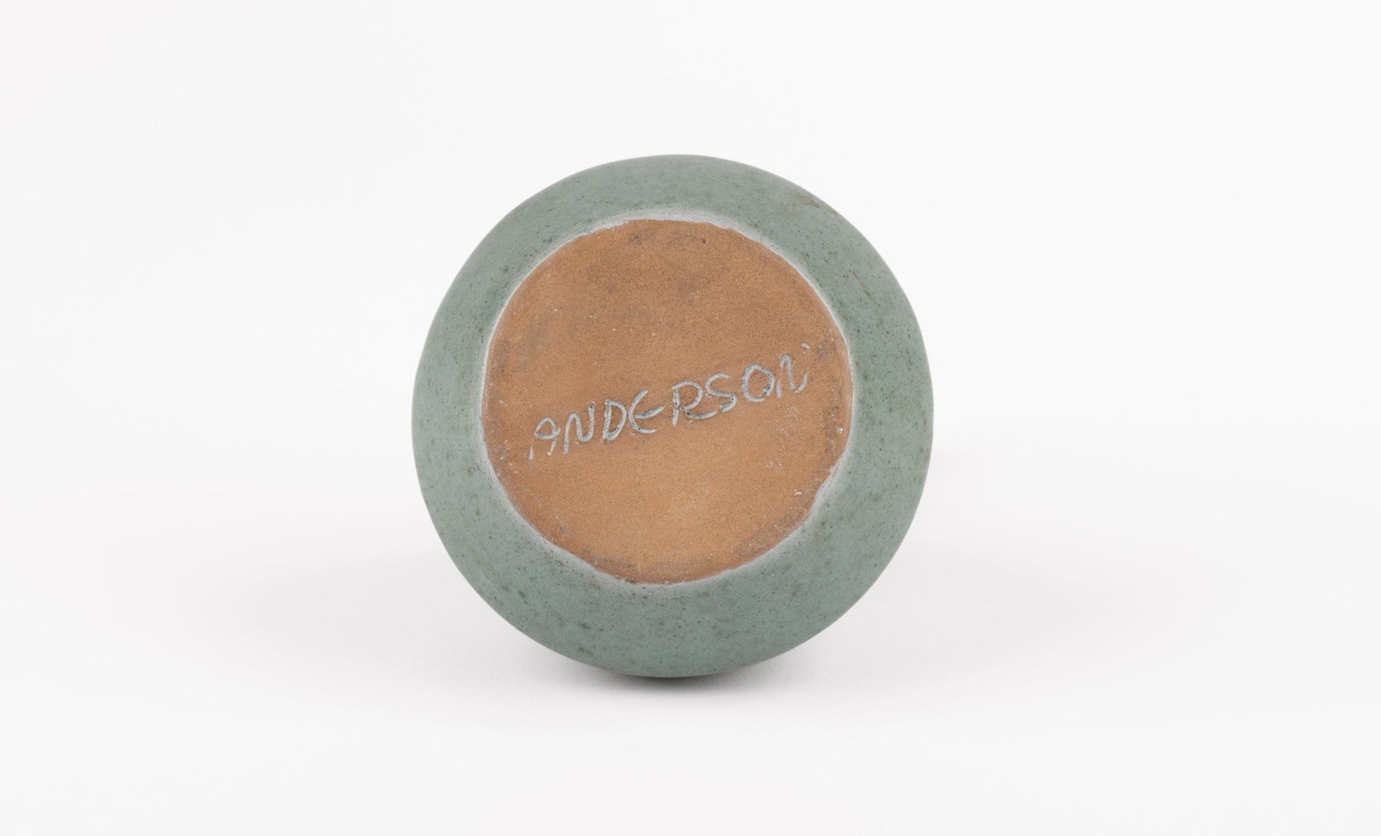 Base of abstract celadon studio pottery vase with handwritten "ANDERSON" signature on white background