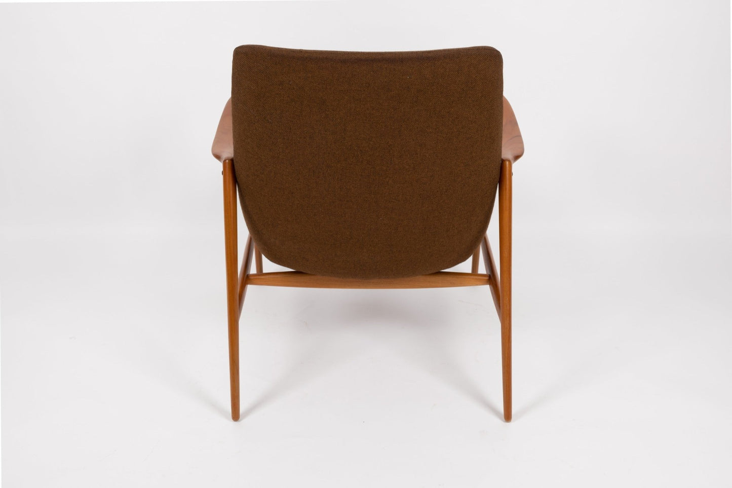 Mid-century modern Adolf Relling lounge chair with sculptural teak frame and brown wool upholstery, rear view on white background.