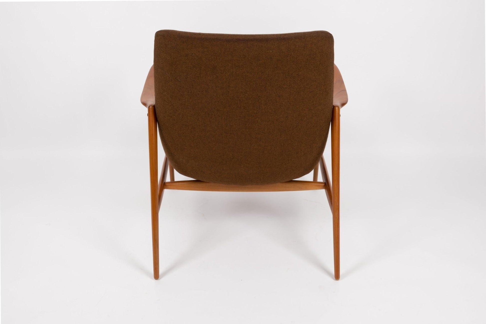 Mid-century modern Adolf Relling lounge chair with sculptural teak frame and brown wool upholstery, rear view on white background.