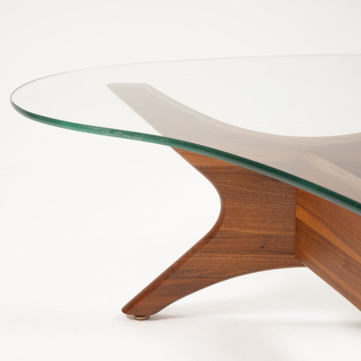 Close-up of Adrian Pearsall coffee table corner featuring sculptural solid walnut leg supporting curved glass top