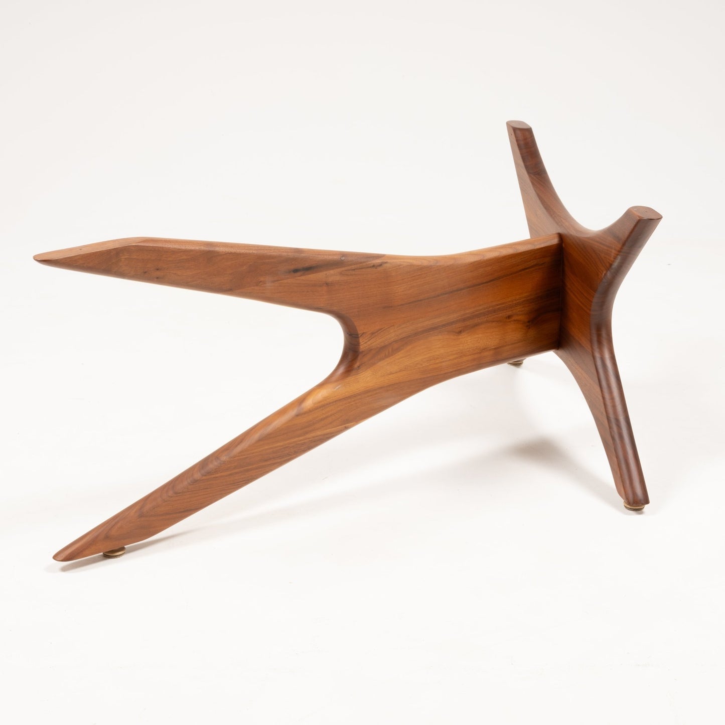 Sculptural solid walnut base with four elongated, curved legs arranged in a star-shaped design on white background