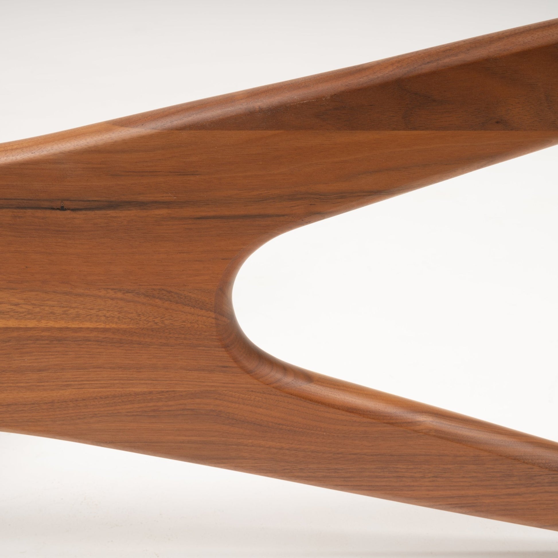 Close-up of solid walnut leg with smooth sculptural curves and natural wood grain from Adrian Pearsall coffee table base