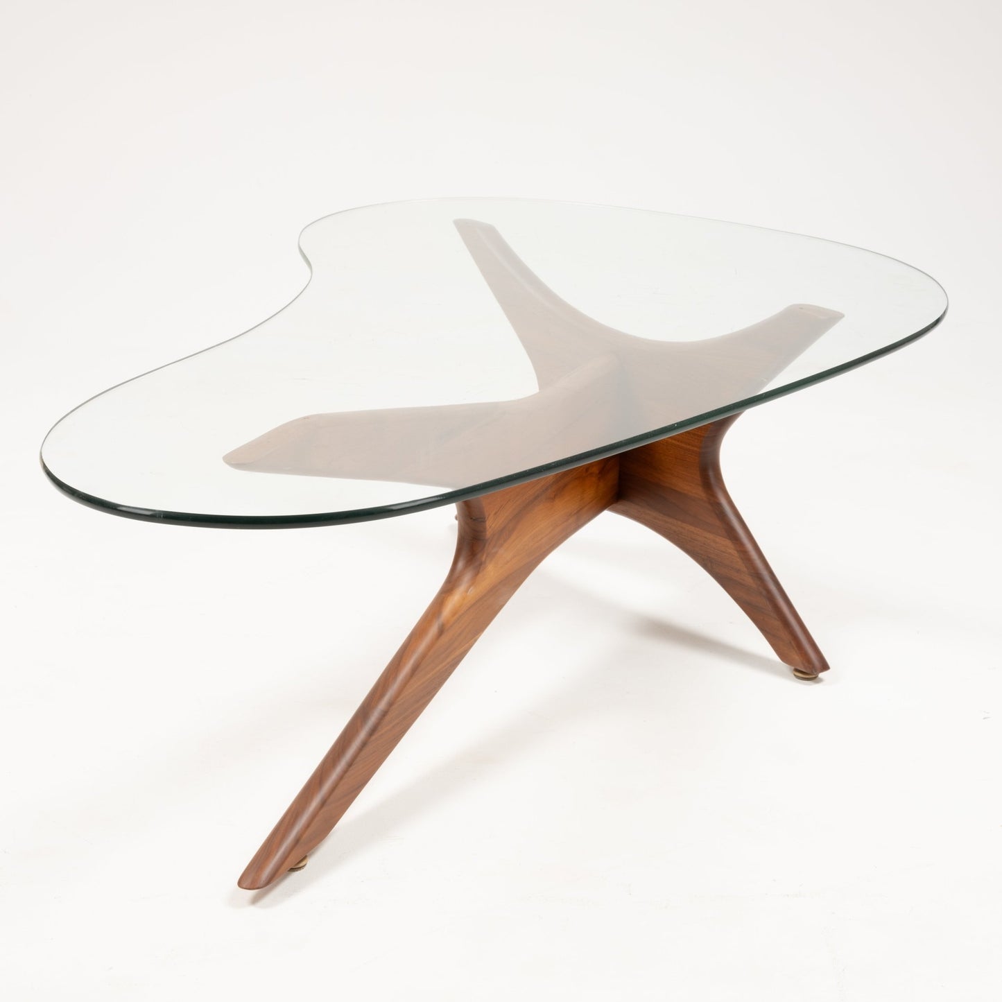Adrian Pearsall “Jacks” coffee table with sculptural solid walnut base and organic-shaped clear glass top on white background