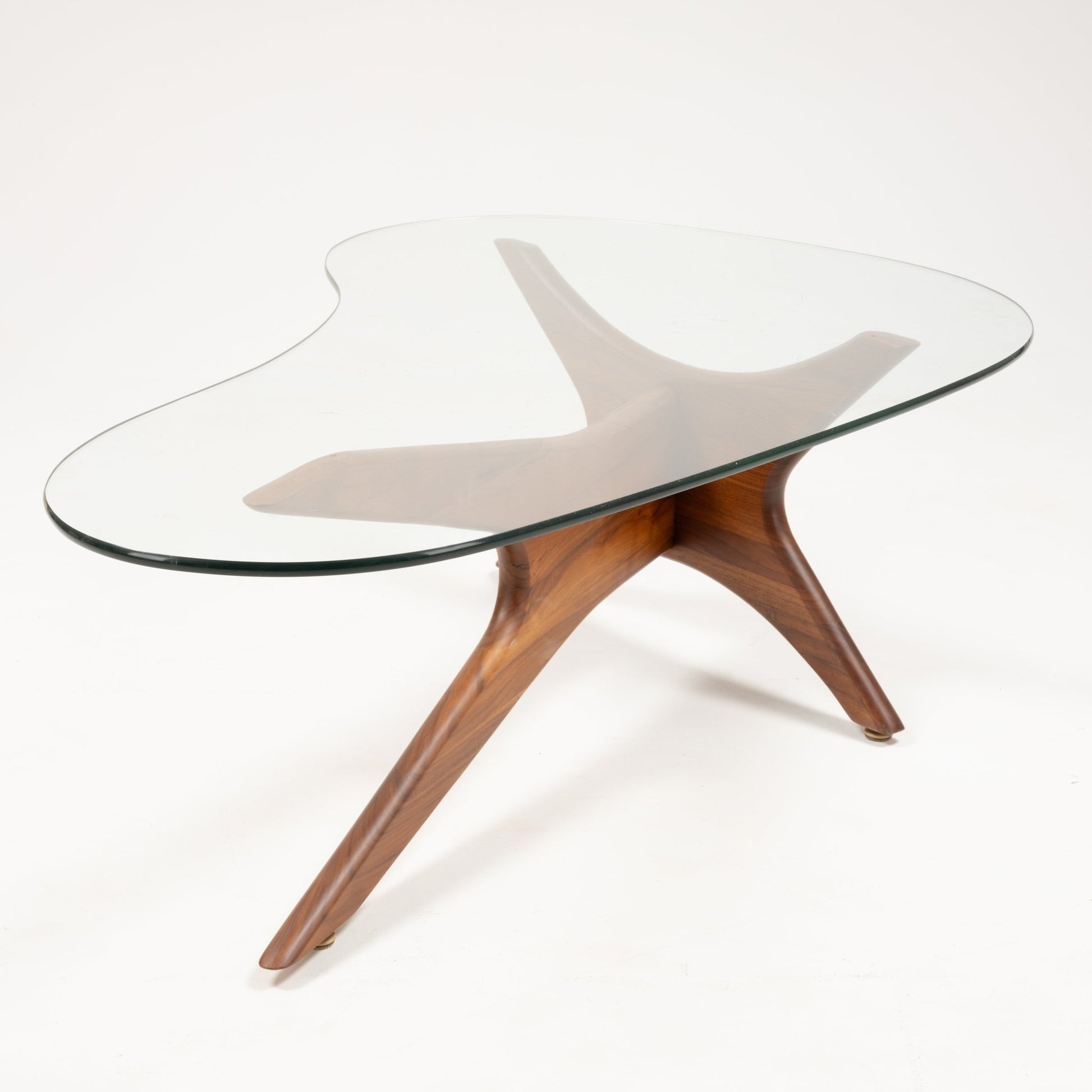 Adrian Pearsall “Jacks” coffee table with sculptural solid walnut base and organic-shaped clear glass top on white background