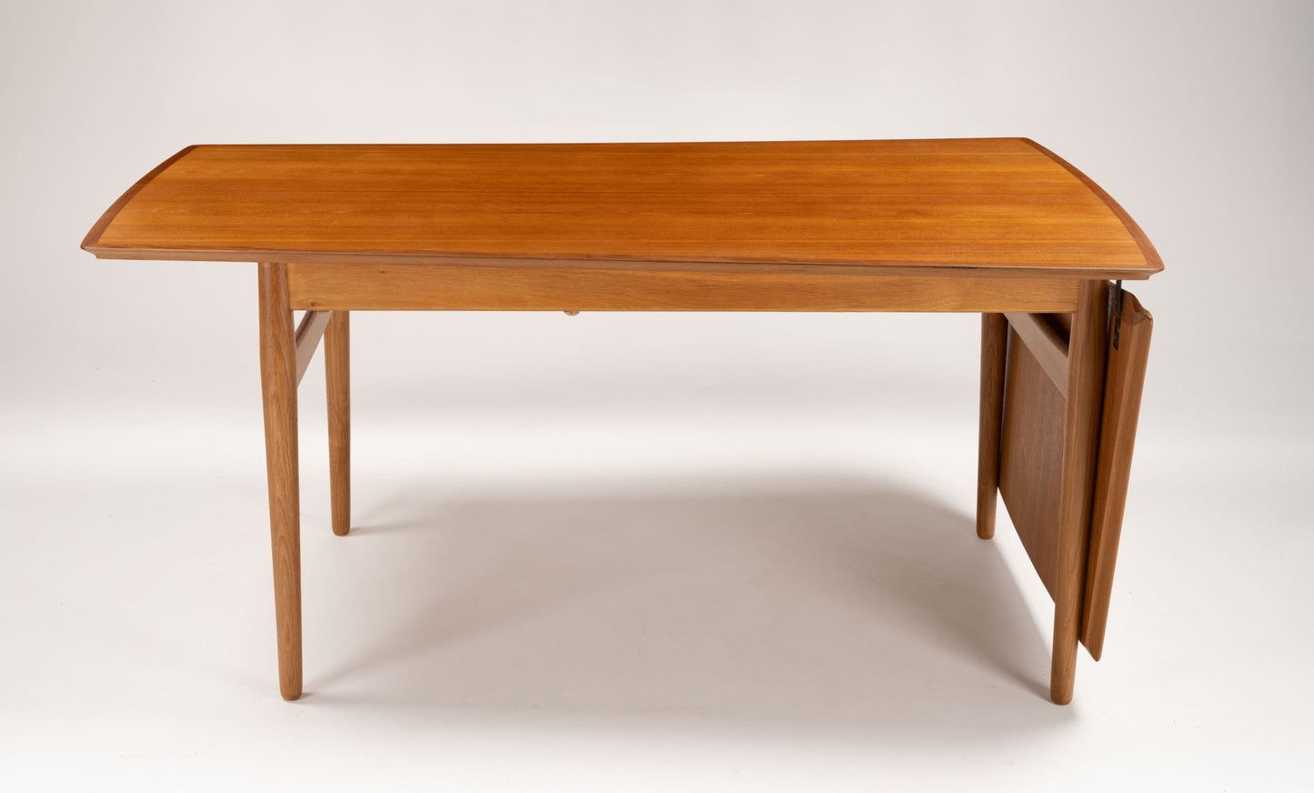 Mid-century modern Arne Vodder teak drop-leaf desk with angled tapered legs and extended workspace on white background