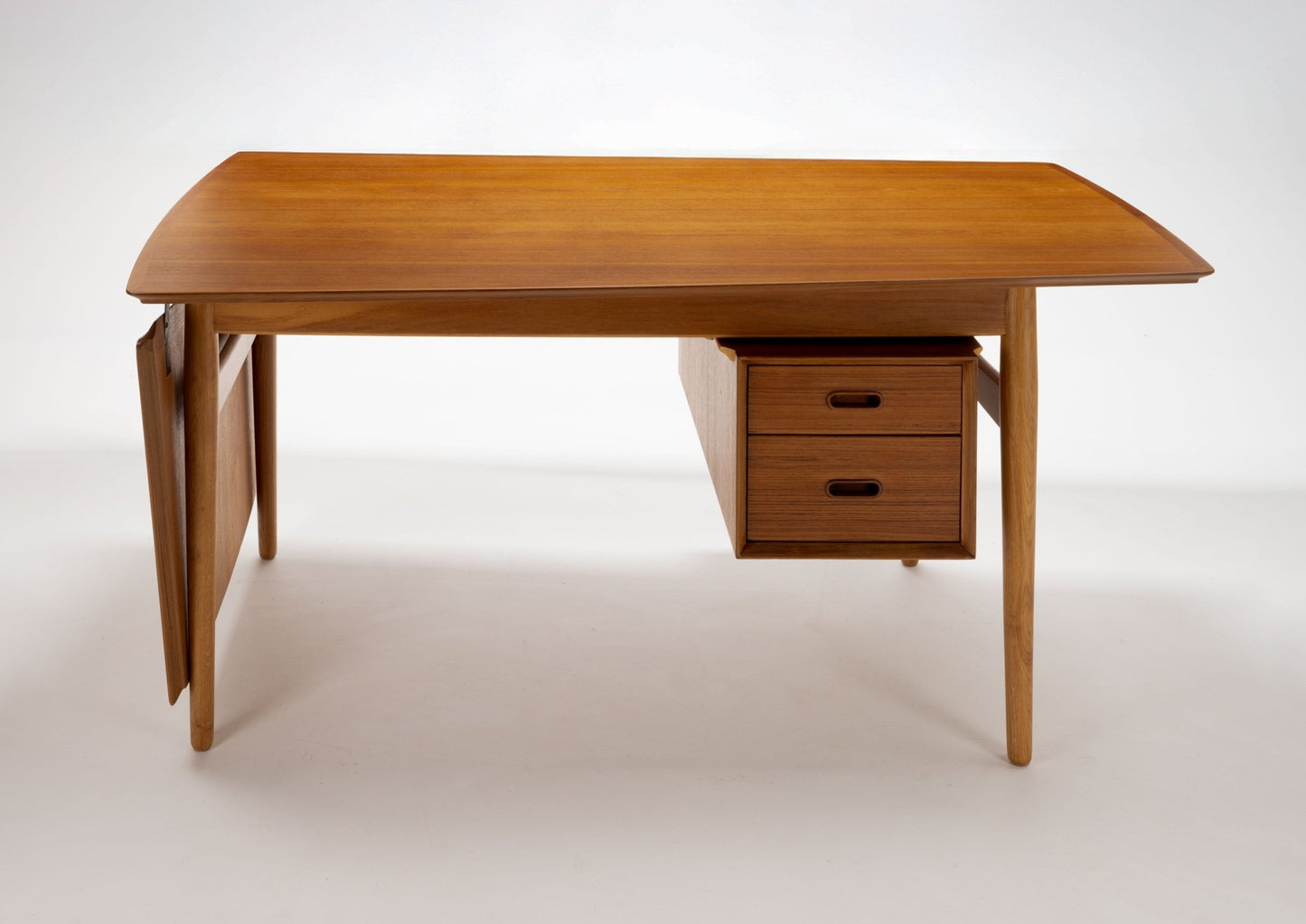Arne Vodder mid-century modern teak drop leaf desk with two drawers and tapered legs on white background