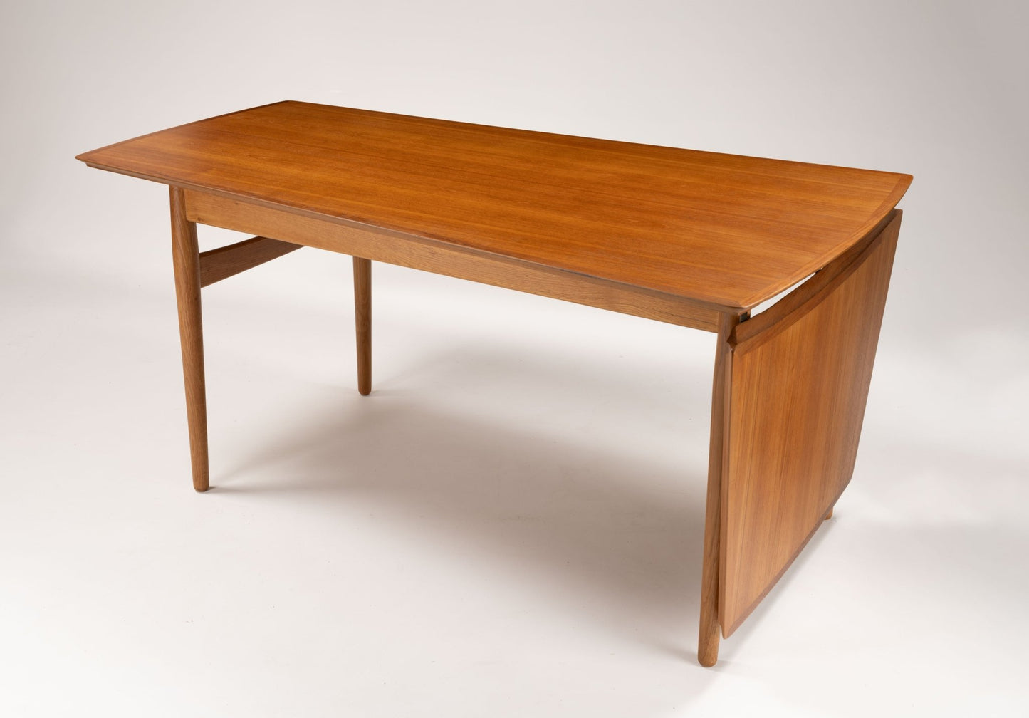 Mid-century modern Arne Vodder teak drop-leaf desk with tapered legs and extended workspace on white background
