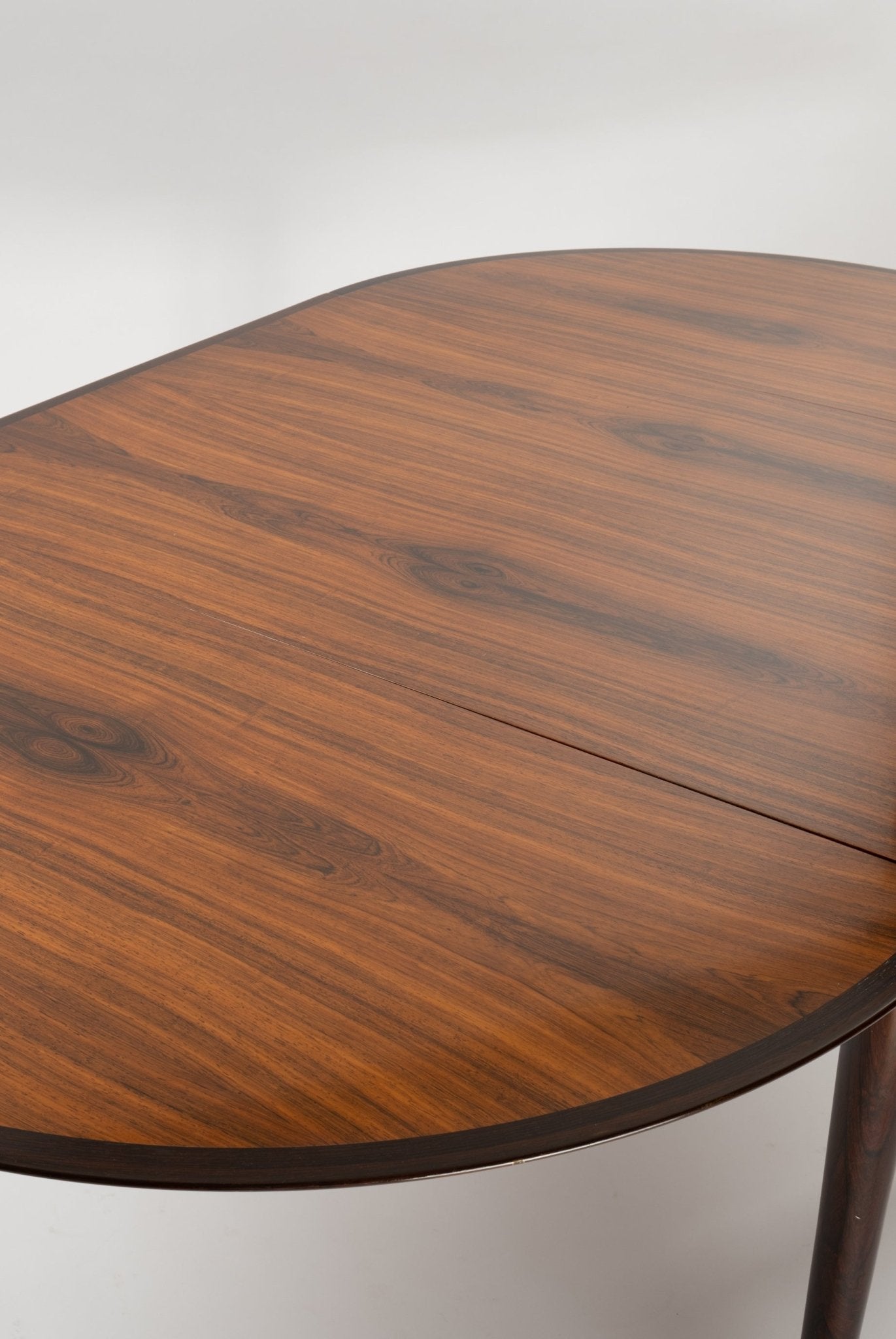 Close-up of mid-century modern Arne Vodder drop leaf rosewood dining table top with visible wood grain and natural finish