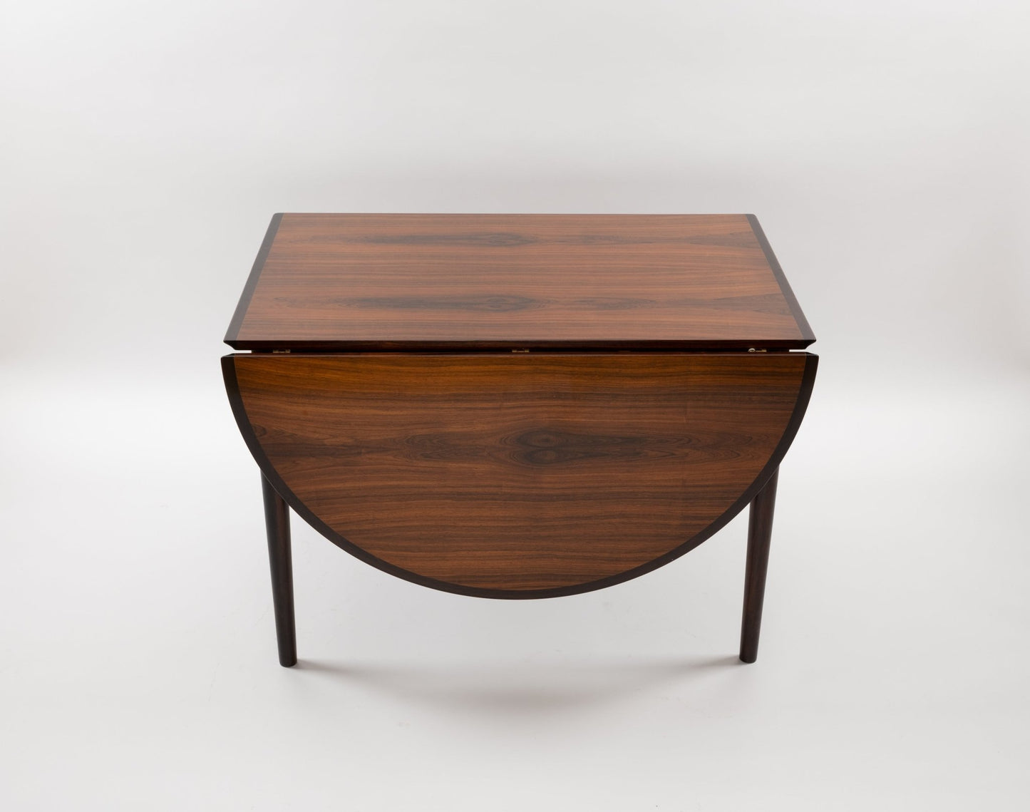 Arne Vodder mid-century modern rosewood drop leaf dining table with tapered legs and clean lines on white background