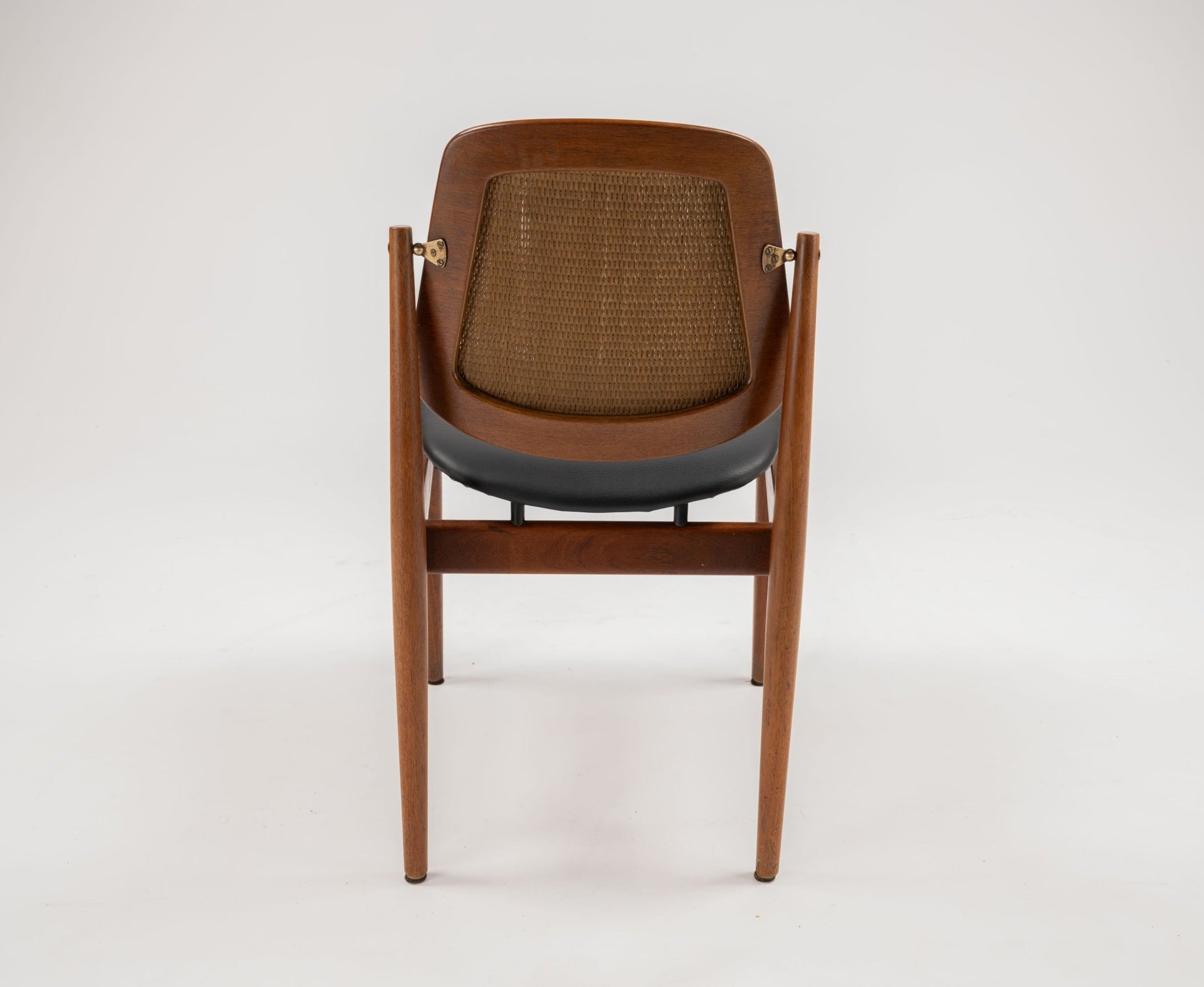 1950s Danish teak dining chair by Arne Vodder with sculpted frame, brass fittings, and woven backrest viewed from rear