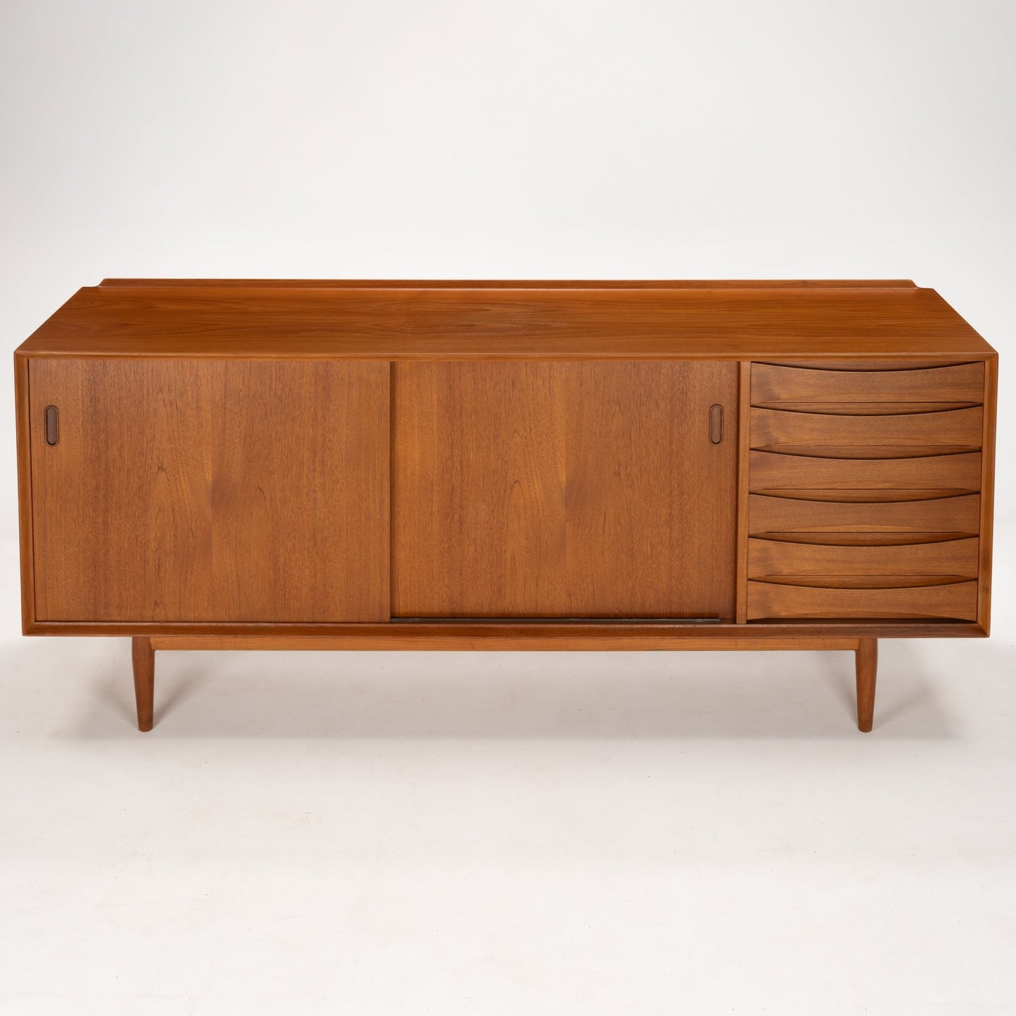 Arne Vodder Reversible-Drawer Teak Credenza for Sibast featuring rich teak wood with smooth sliding doors and a stylish column of sculpted drawers, supported by tapered legs in mid century modern style.