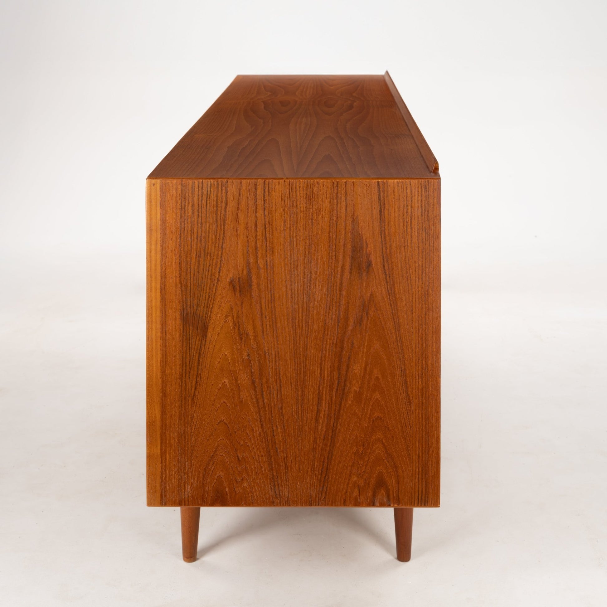 Arne Vodder Reversible-Drawer Teak Credenza for Sibast showcasing the warm teak wood side panel with rich grain patterns and tapered legs reflecting elegant mid century modern furniture design.