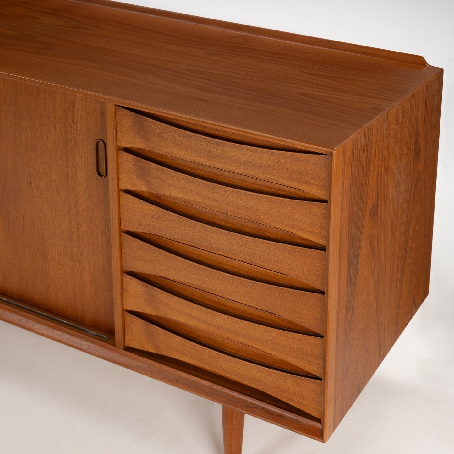 Arne Vodder Reversible-Drawer Teak Credenza for Sibast featuring smooth sliding doors and six curved wooden drawers with sculpted handles, crafted in warm teak wood with tapered legs.