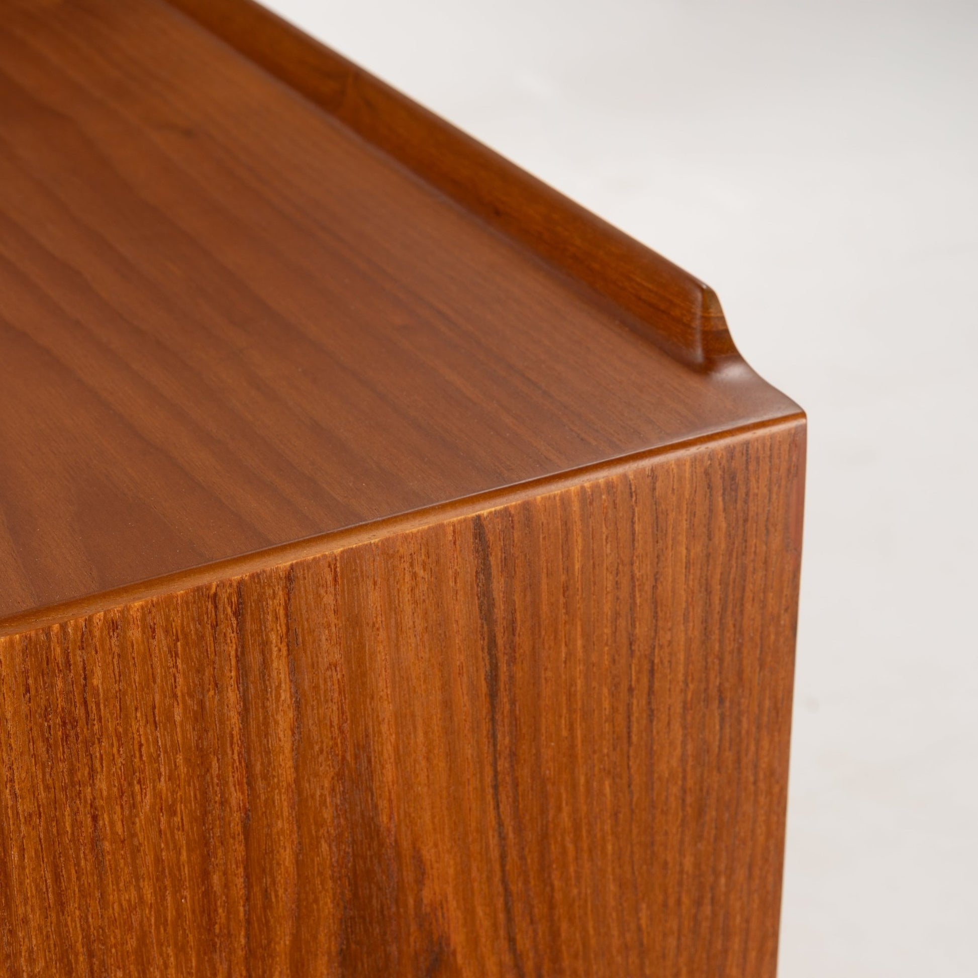 Arne Vodder Reversible-Drawer Teak Credenza for Sibast showing close-up detail of the wood grain and gently rounded edge with raised lip, highlighting fine craftsmanship and warm teak finish.