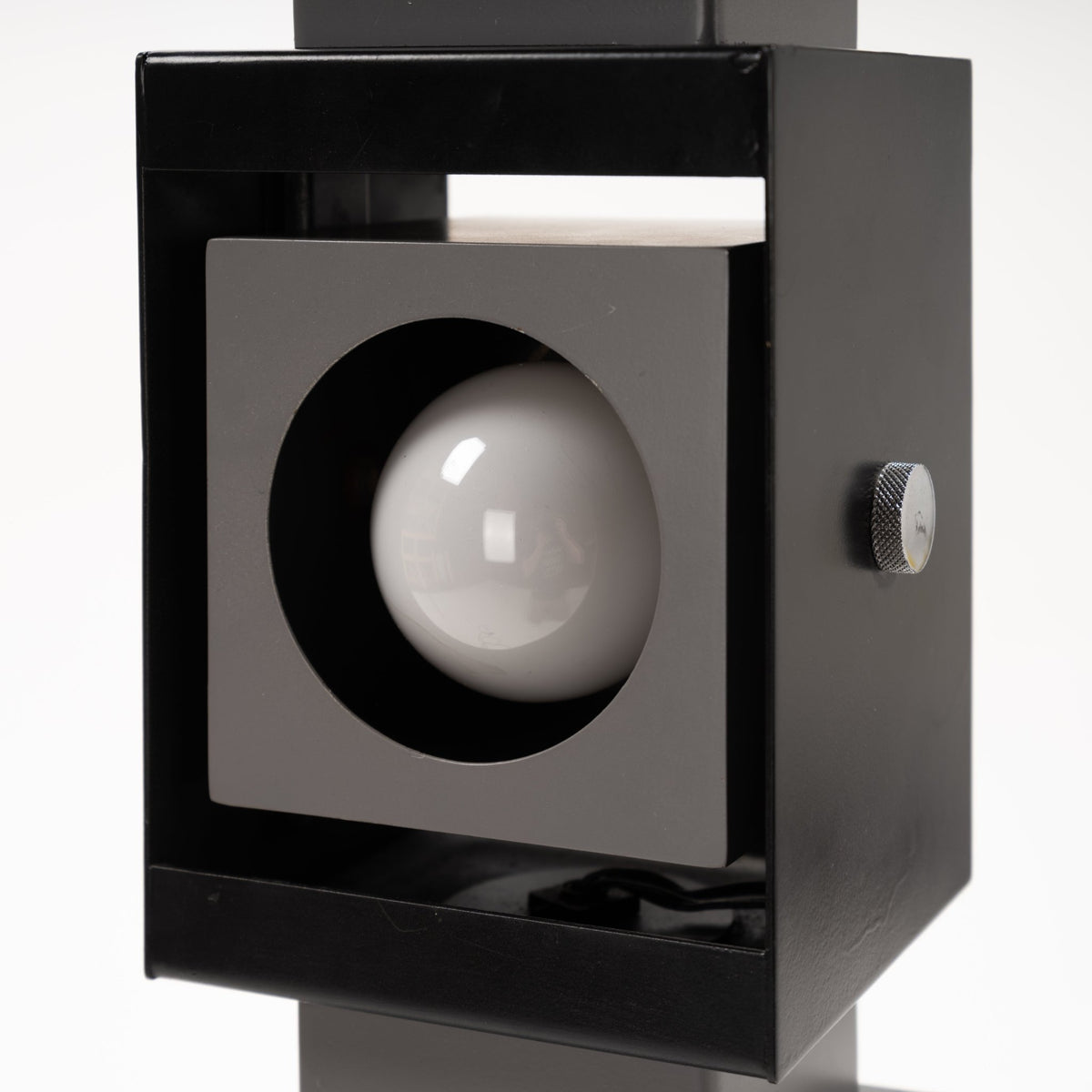 Arteluce Swivel Steel Floor Lamp closeup featuring a black steel square spotlight housing with exposed round bulb and side adjustment knob for modern lighting