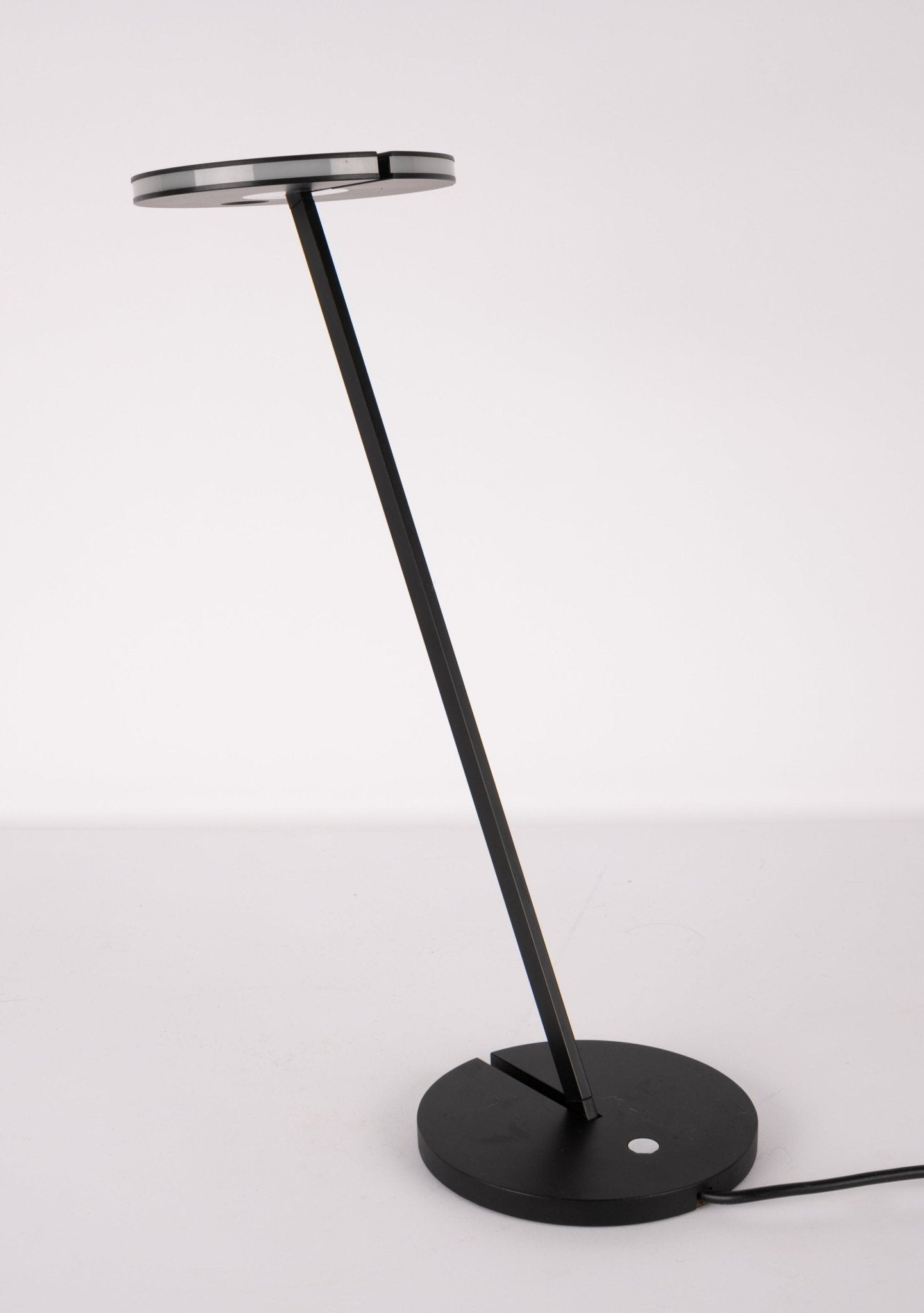 Minimalist Artemide Itis LED table lamp with slim angled arm and circular base in matte black finish.