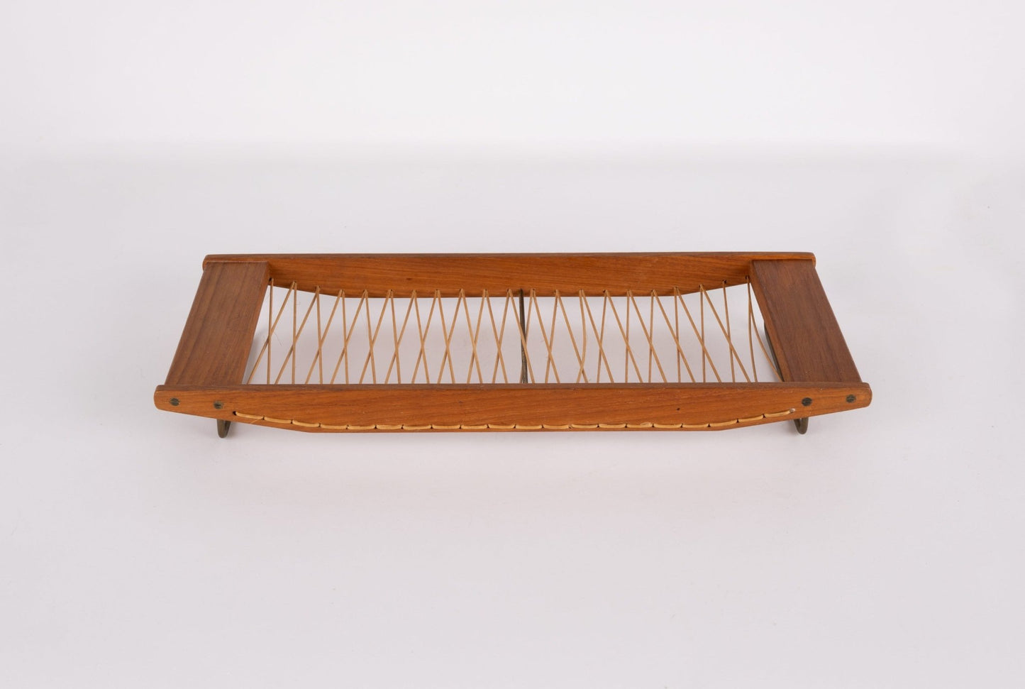 Danish 1960s teak bread tray with woven rattan center and brass hardware on a white background