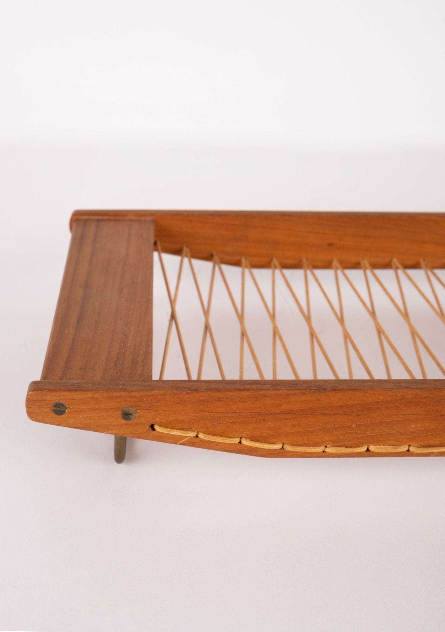 Mid-century Danish teak bread tray with rattan weaving and brass hardware, showcasing minimalist Scandinavian design.
