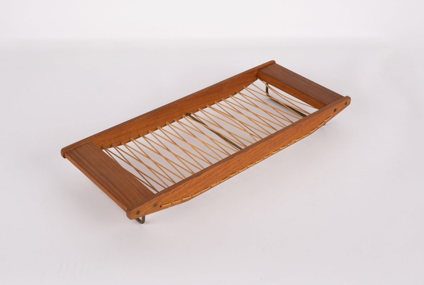 Danish mid-century modern teak bread tray with woven rattan center and brass hardware on white background.