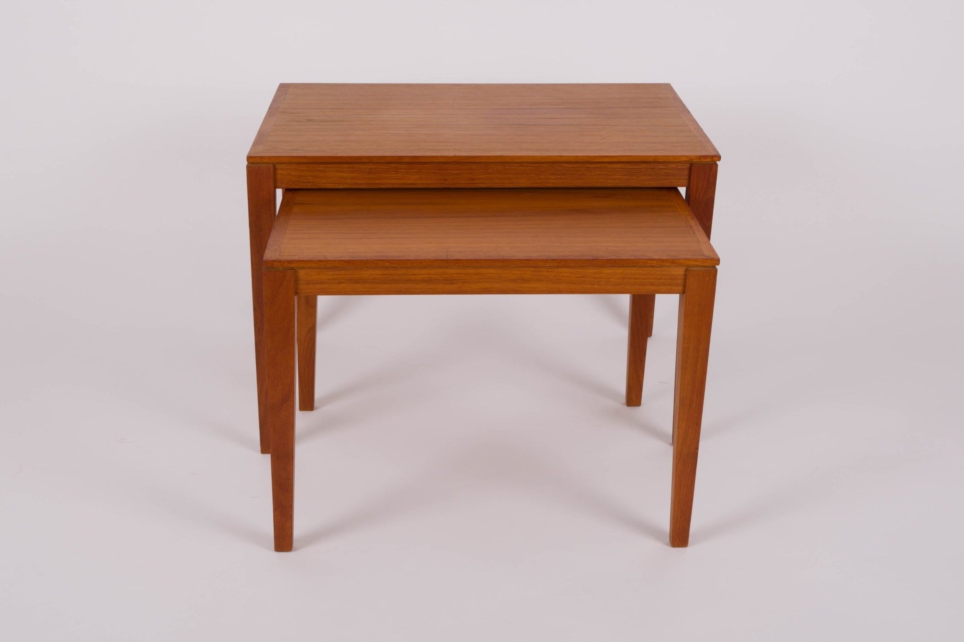 Pair of Bent Silberg mid-century modern teak nesting tables with tapered legs and clean minimalist design