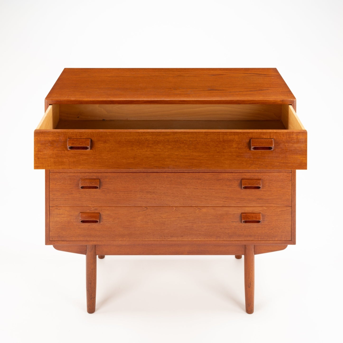 Mid-century wooden dresser with three drawers, cutout rectangular handles, and tapered legs in warm brown finish