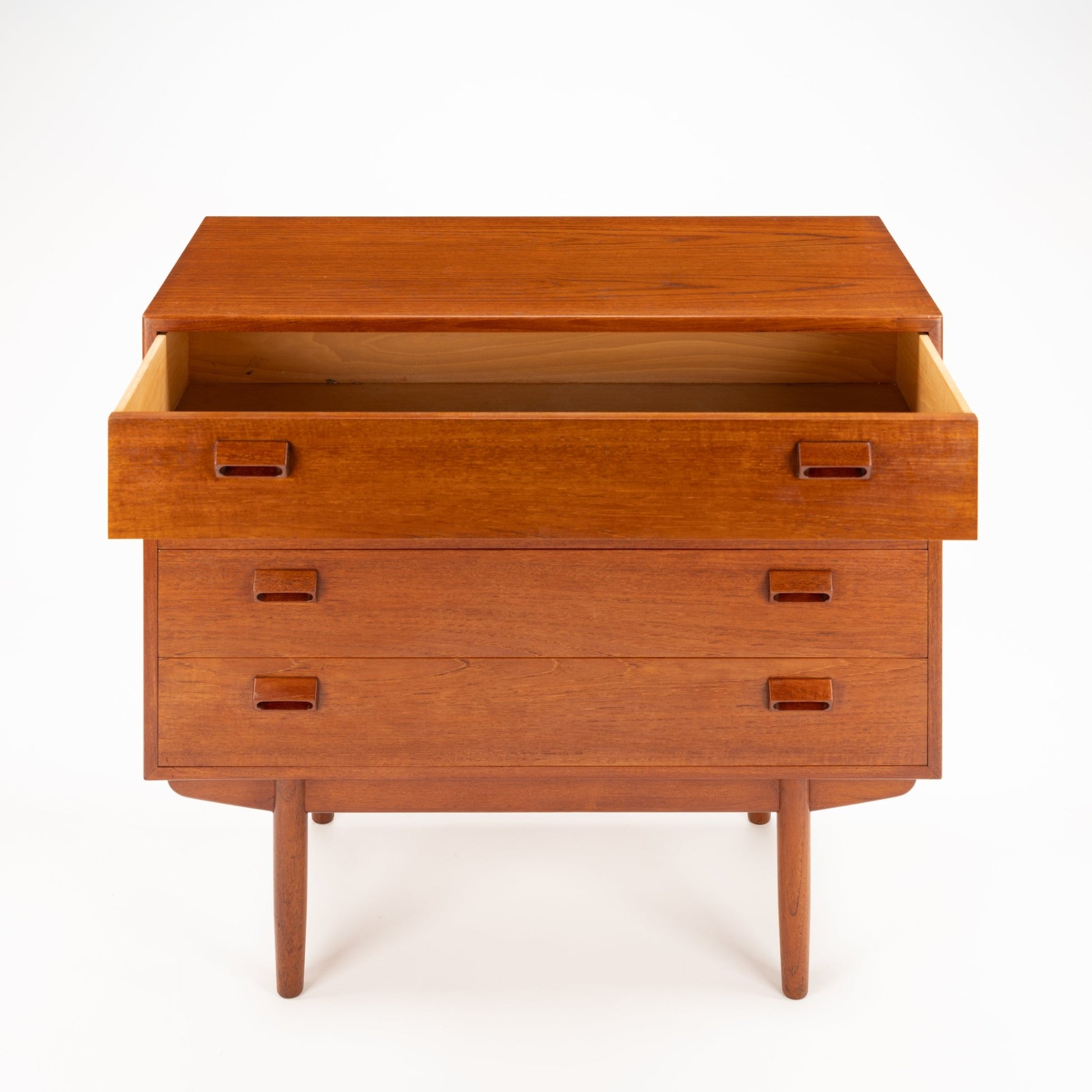 Mid-century wooden dresser with three drawers, cutout rectangular handles, and tapered legs in warm brown finish