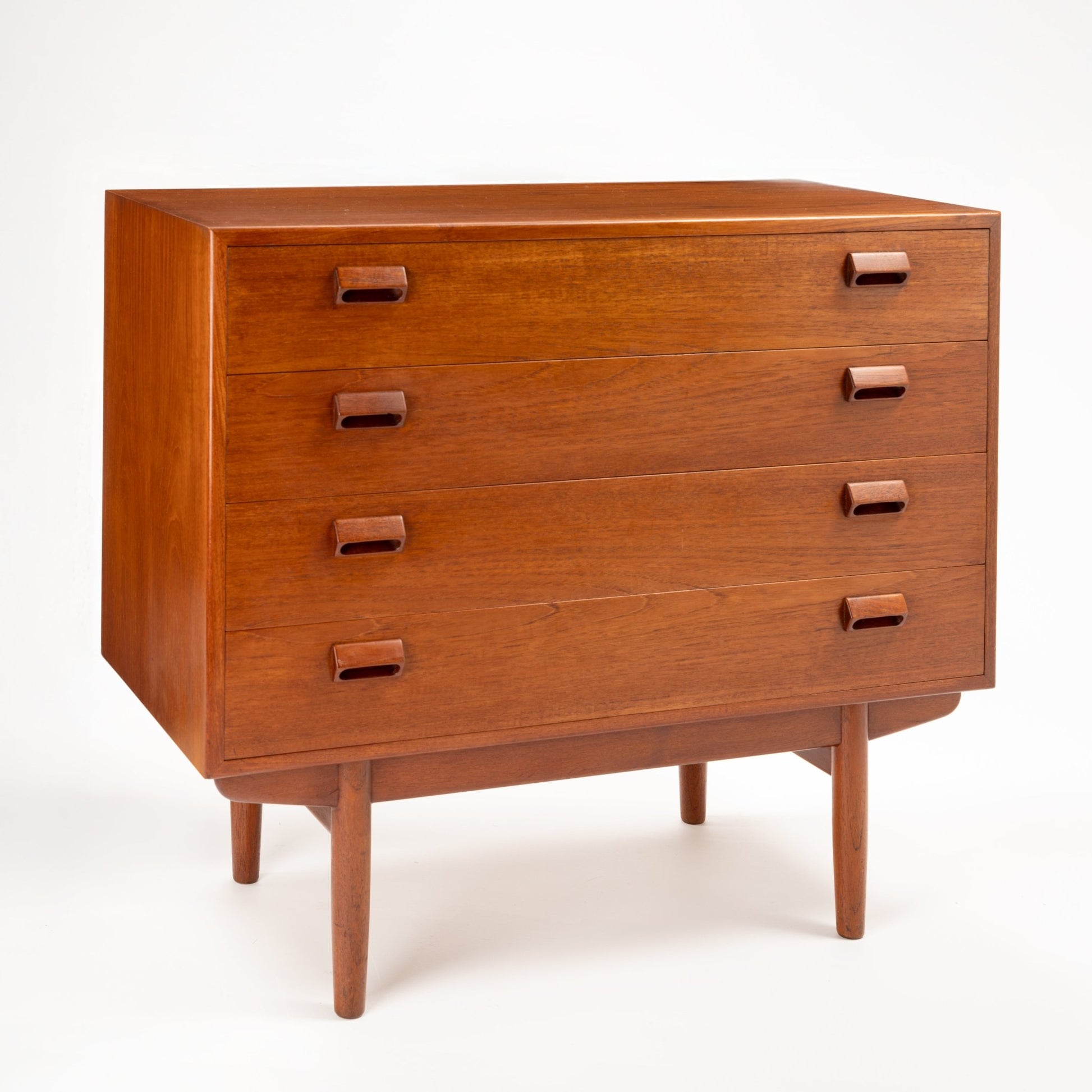 Three-drawer wooden dresser with rectangular wooden handles and tapered legs in warm mid-century finish