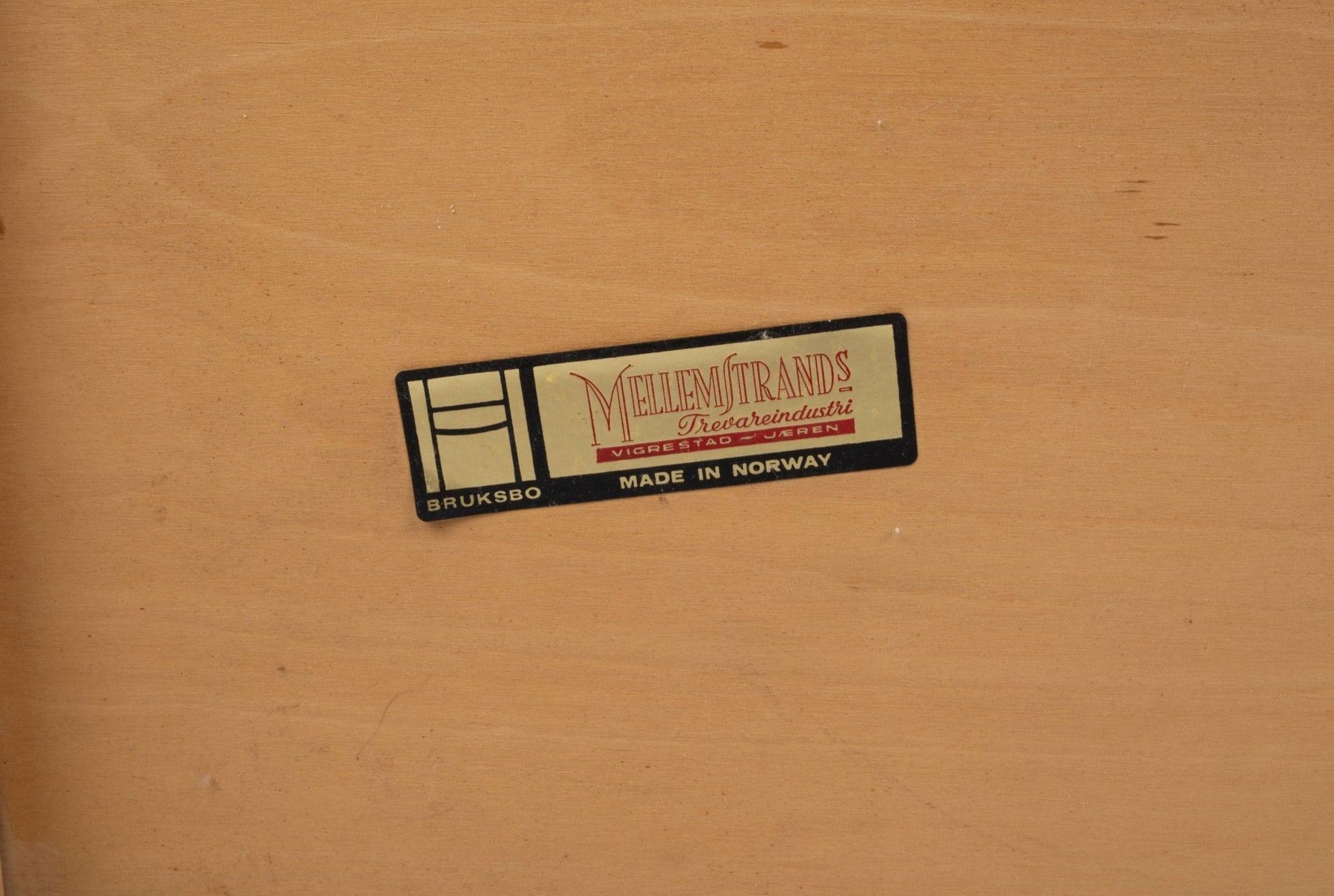 Close-up of Bruksbo label on rosewood rolling cart, indicating Made in Norway and Millentrands branding.