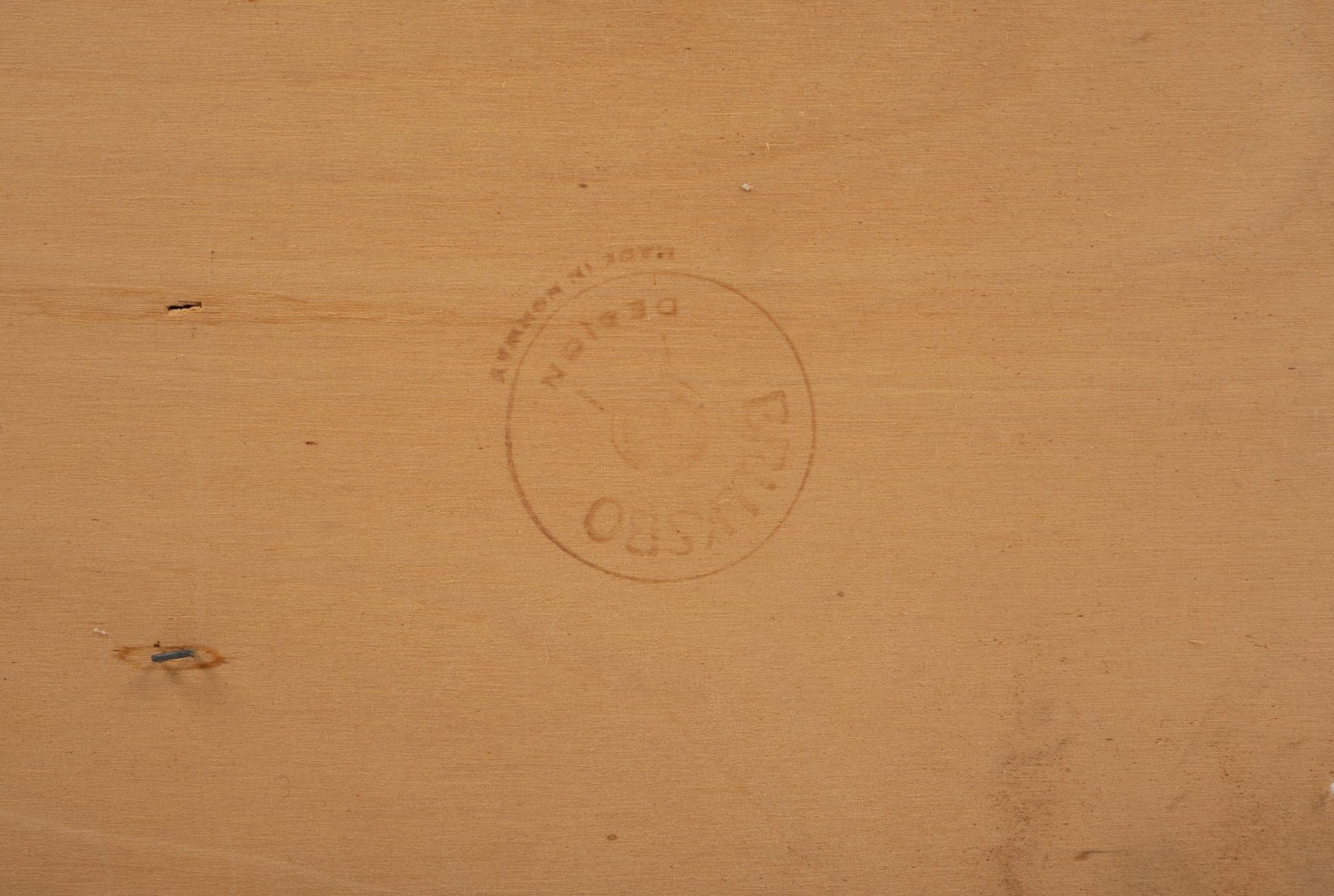 Close-up of Bruksbo brand stamp on light wood surface of rosewood rolling cart showing maker's mark details.