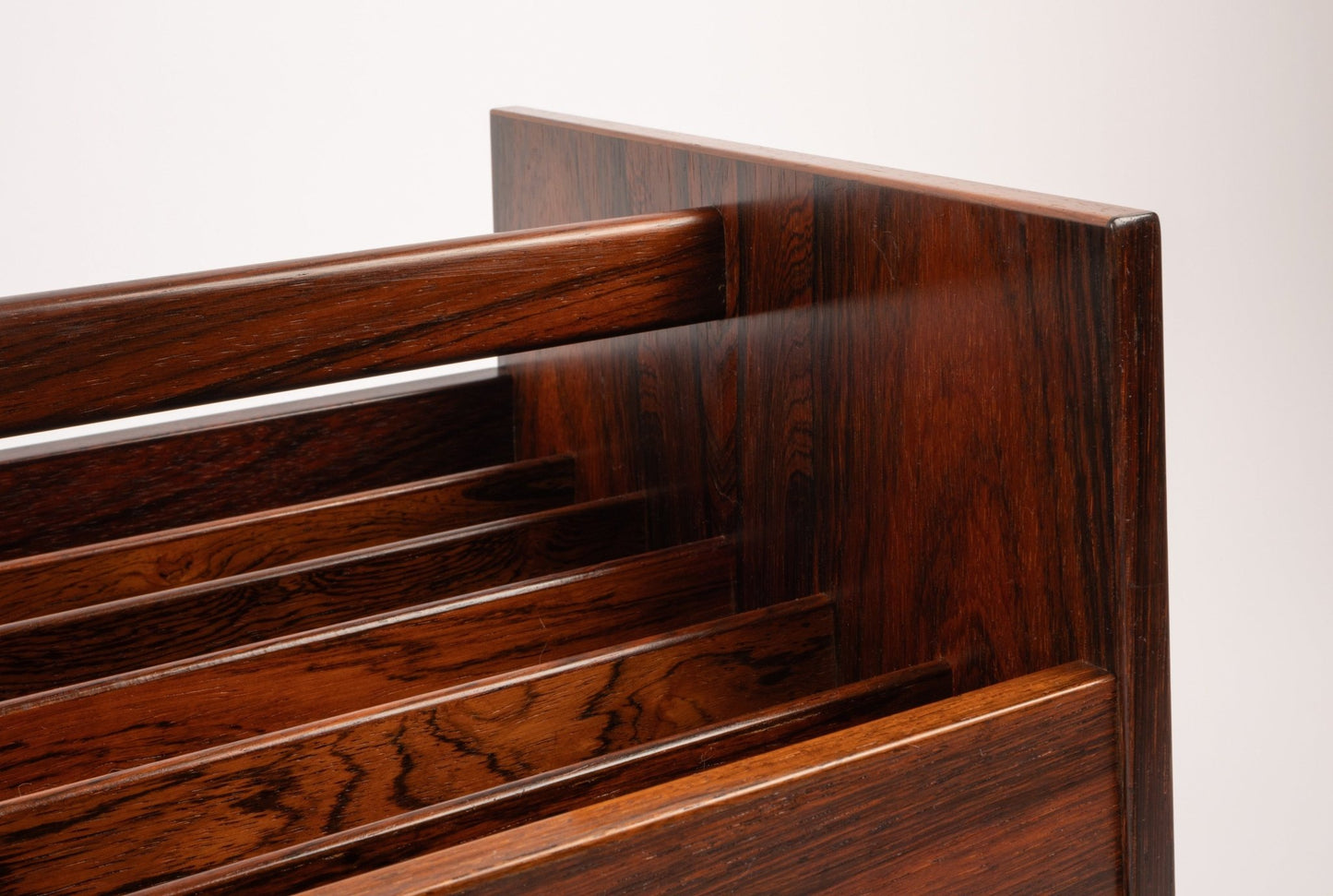 Close-up of Bruksbo rosewood rolling cart featuring rich wood grain and slatted compartments for magazines or records.