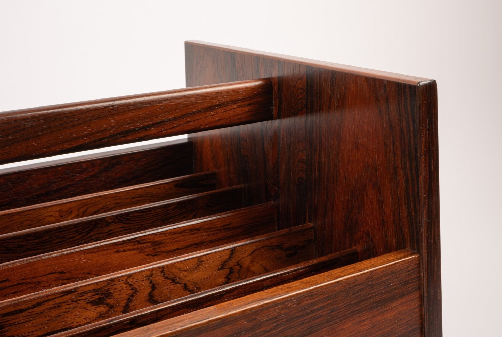 Close-up of Bruksbo rosewood rolling cart featuring rich wood grain and slatted compartments for magazines or records.